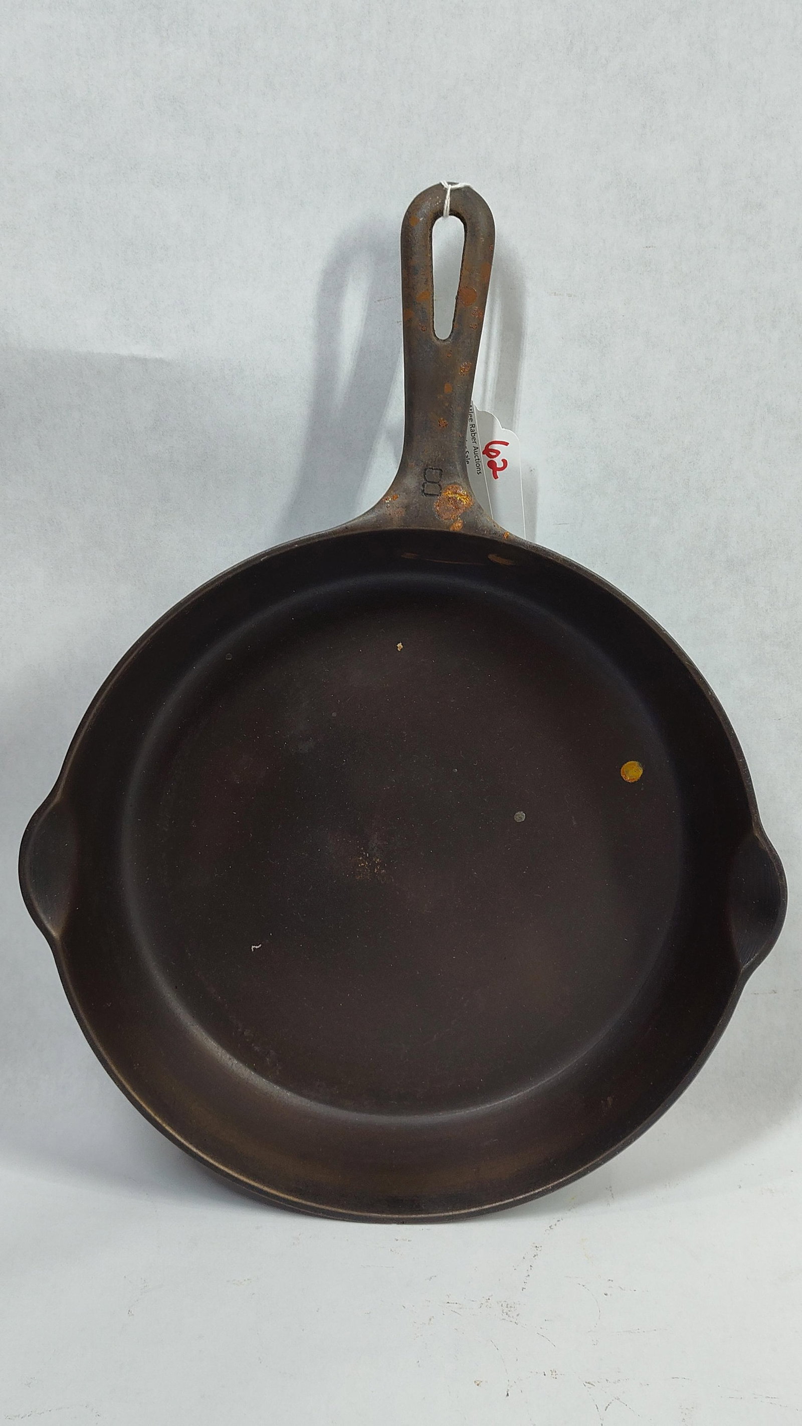 Griswold No. 8 Cast Iron Skillet with Small Logo Erie PA Pattern 704 A: This is a Griswold No. 8 cast iron skillet manufactured in Erie, Pennsylvania. The underside of the skillet features the trademark Griswold small logo, which consists of a cross within a circle. The b