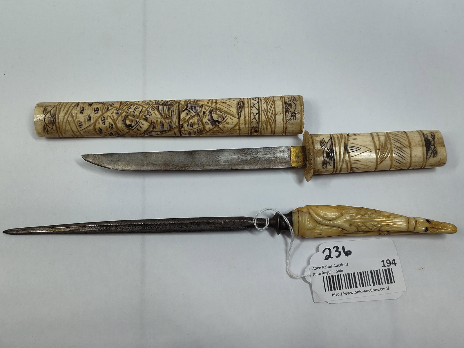 Two Japanese-Style Edged Weapons with Carved Bone Handles: This lot includes two Japanese-style edged implements featuring hand-carved bone components. The first item is a tanto-style blade in an aikuchi mounting, consisting of a steel blade with a brass haba