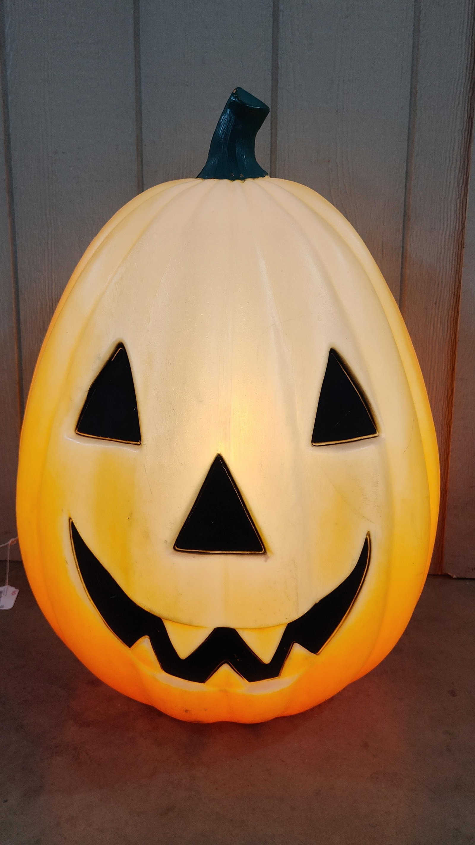 Large Gradient Color Lighted Jack-O-Lantern Blow Mold Decoration: This holiday decoration is a large-scale jack-o-lantern crafted from blow-molded plastic. The piece features a distinctive gradient color scheme, transitioning from a creamy off-white at the top to a 