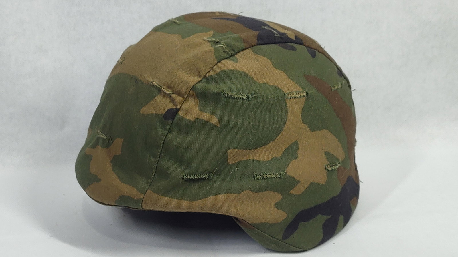 US Military PASGT Ballistic Helmet with Woodland Camouflage Cover, Size Medium: This is a United States military Personnel Armor System for Ground Troops (PASGT) ballistic helmet, commonly referred to as a Kevlar helmet. The shell is constructed from layers of Kevlar aramid fiber