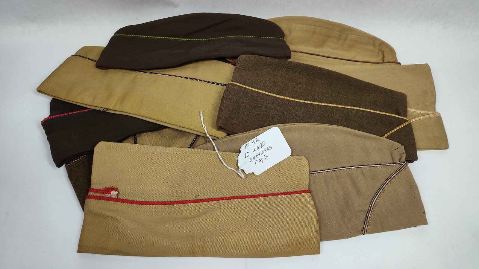 Ten World War II United States Military Overseas Garrison Caps: ten authentic United States military overseas garrison caps dating to the World War II era. This lot contains a variety of branch-specific headgear for the US Army and US Army Air Forces. The assortme