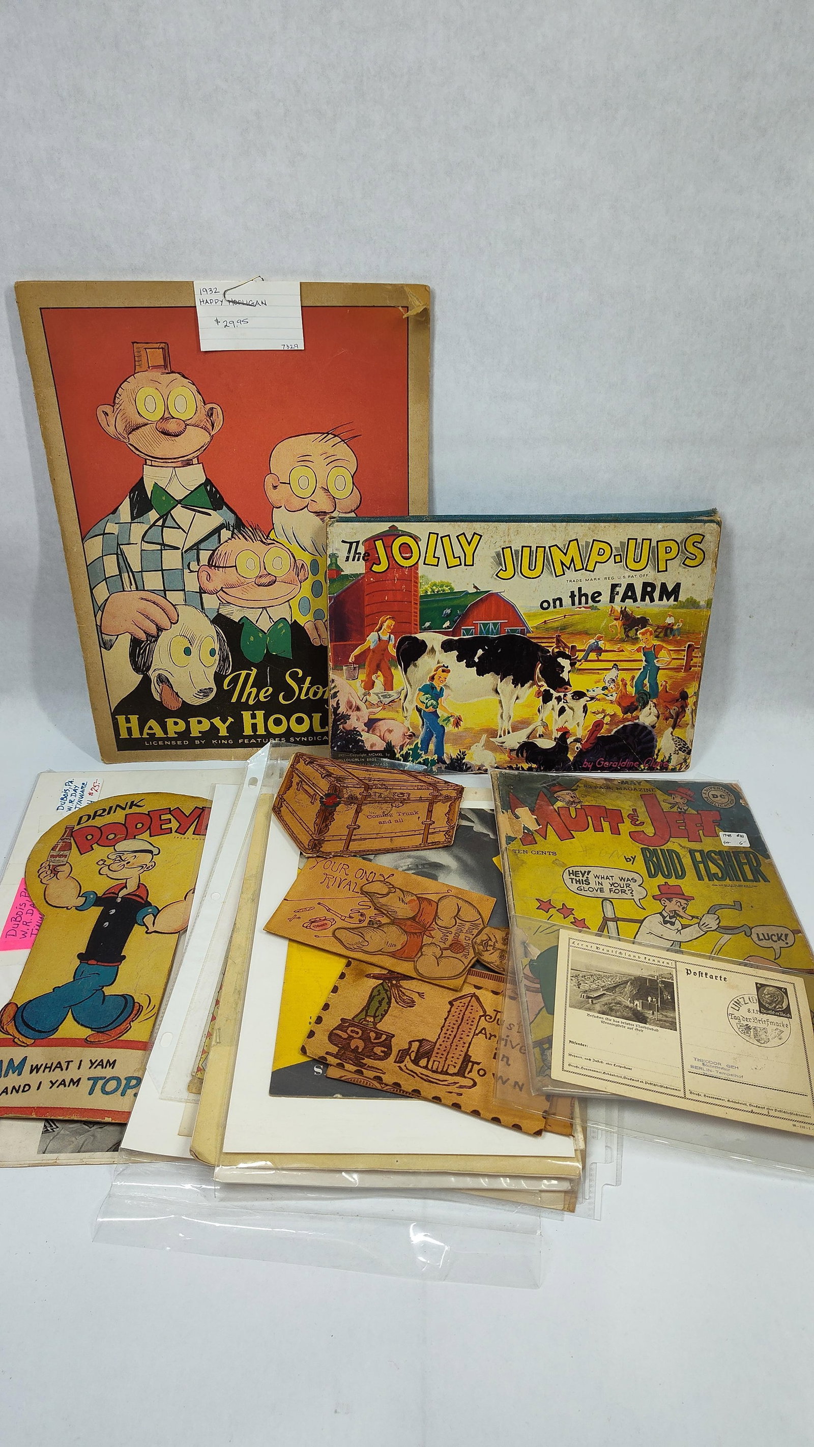 20th Century Comic Memorabilia, Children's Books, and Novelty Leather Ephemera: This lot comprises an assortment of mid-to-early 20th-century American paper and leather ephemera. Included is The Story of Happy Hooligan portfolio, No. 281, licensed by King Features Syndicate, whic