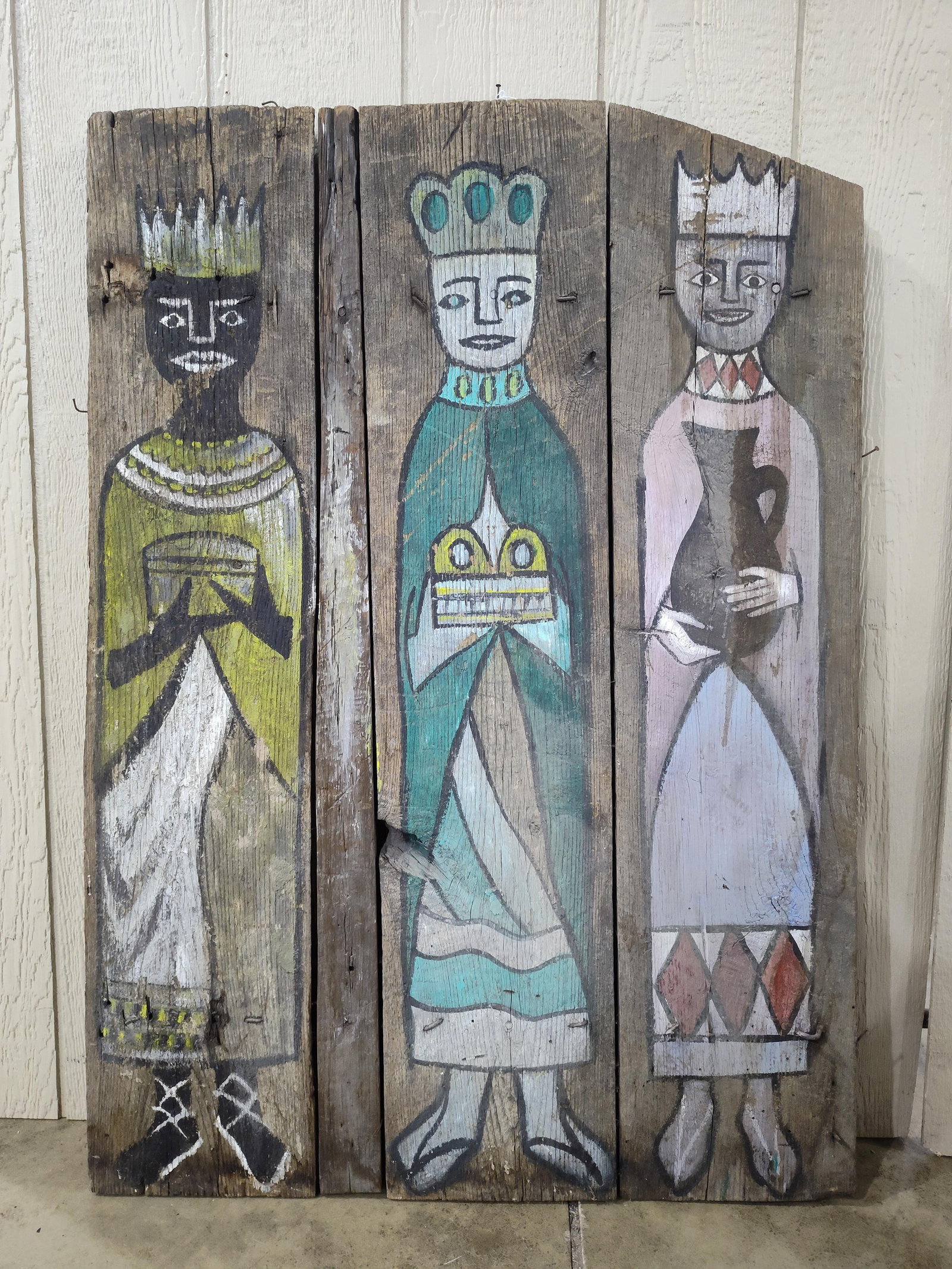 American Folk Art Painting of the Three Magi on Reclaimed Wood Panel: This folk art painting depicts the three Biblical Magi, also known as the Three Wise Men, in a stylized, naive aesthetic. The work is executed in paint on a support consisting of three vertical, weath