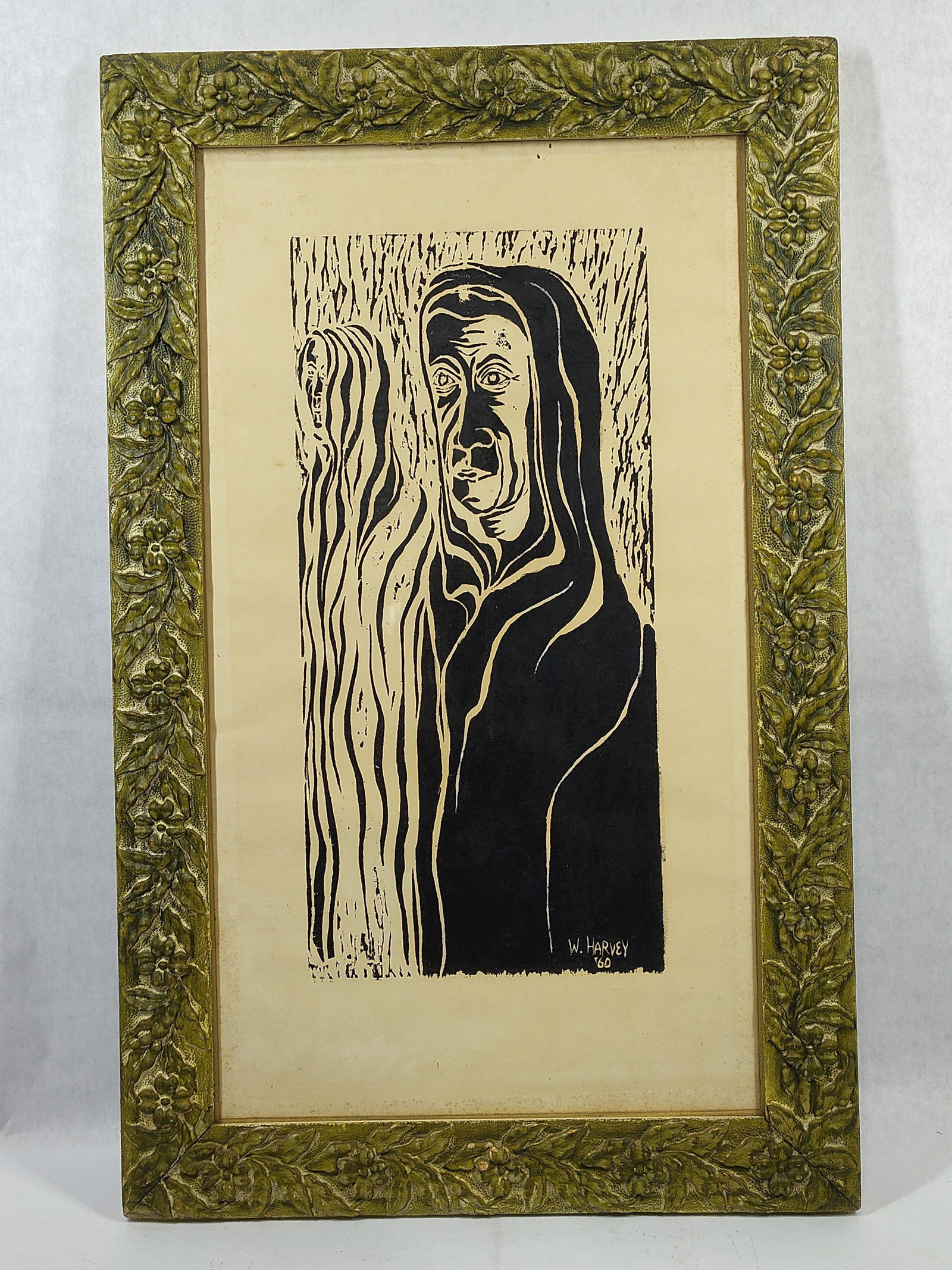 W. Harvey, Expressionist Style Relief Print, 1960: This relief print, executed as either a woodcut or linocut, depicts a stylized and expressive hooded figure positioned beside an elongated, abstract vertical form. The work is characterized by bold, h
