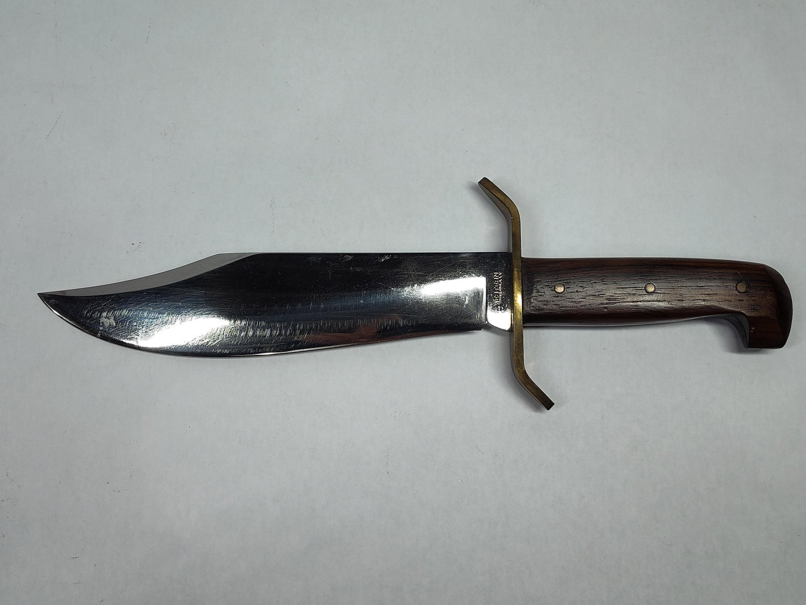 Western Cutlery Co. Model W49 Fixed Blade Bowie Knife: This is a Western Cutlery Company Model W49 Bowie knife, a classic American-made fixed-blade knife. The piece features a large clip-point blade made of polished steel with a full tang. The handle is c