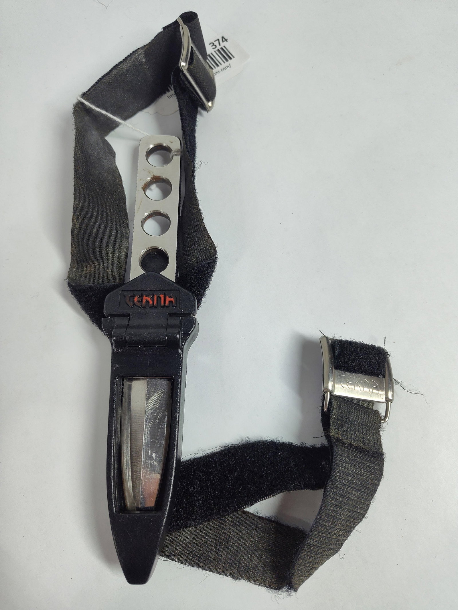 Tekna Ocean Edge Stainless Steel Diving Knife with Sheath and Straps: Tekna Ocean Edge diving knife. The knife features a one-piece skeletonized construction made of stainless steel. The double-edged dagger-style blade has a plain edge with a small serrated section
