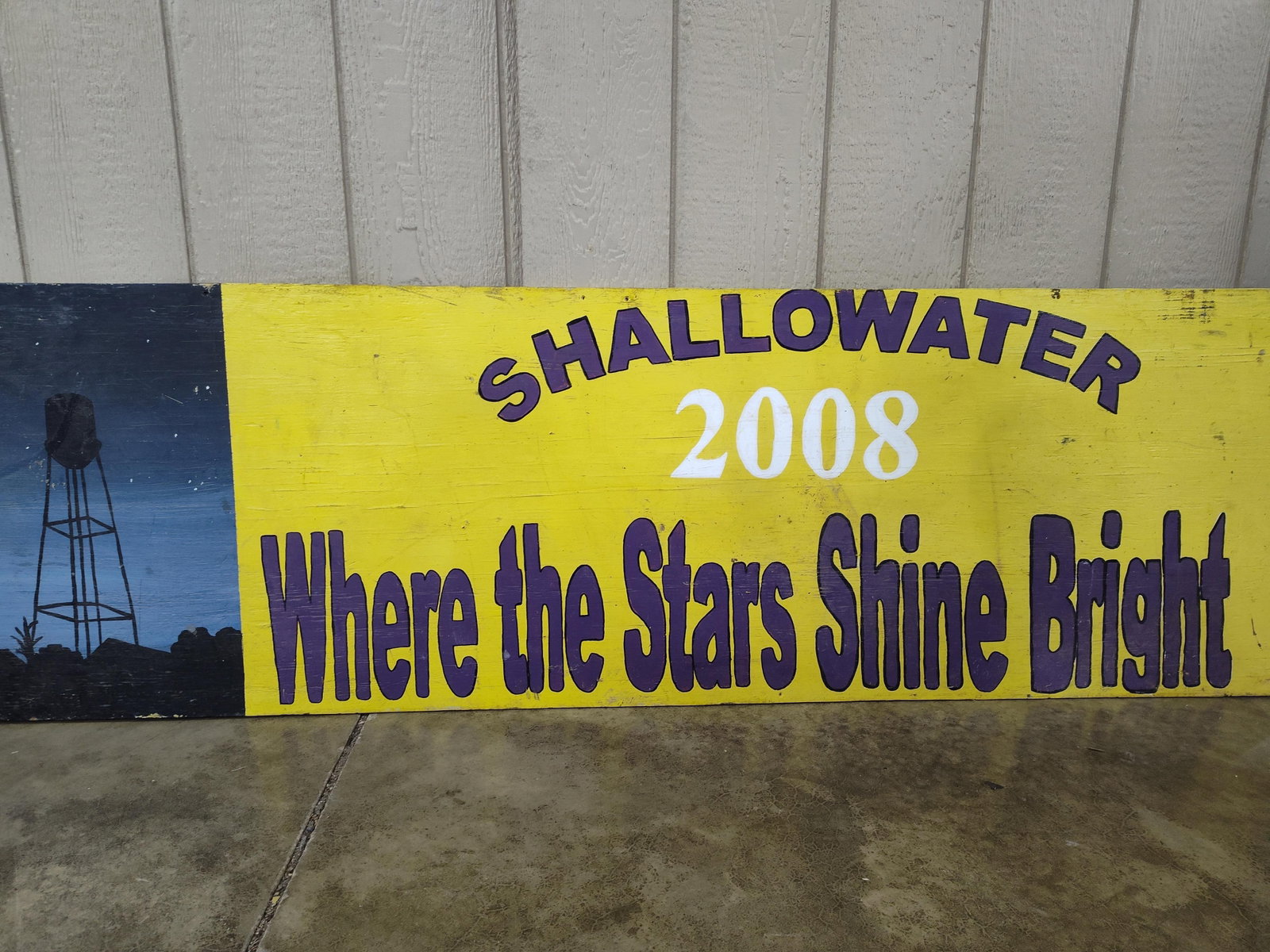 Commemorative Hand-Painted Plywood Sign, Shallowater 2008: This item is a hand-painted spirit or commemorative sign executed on a rectangular plywood board. The sign is divided into two distinct visual sections. On the left, a vertical rectangular panel depic