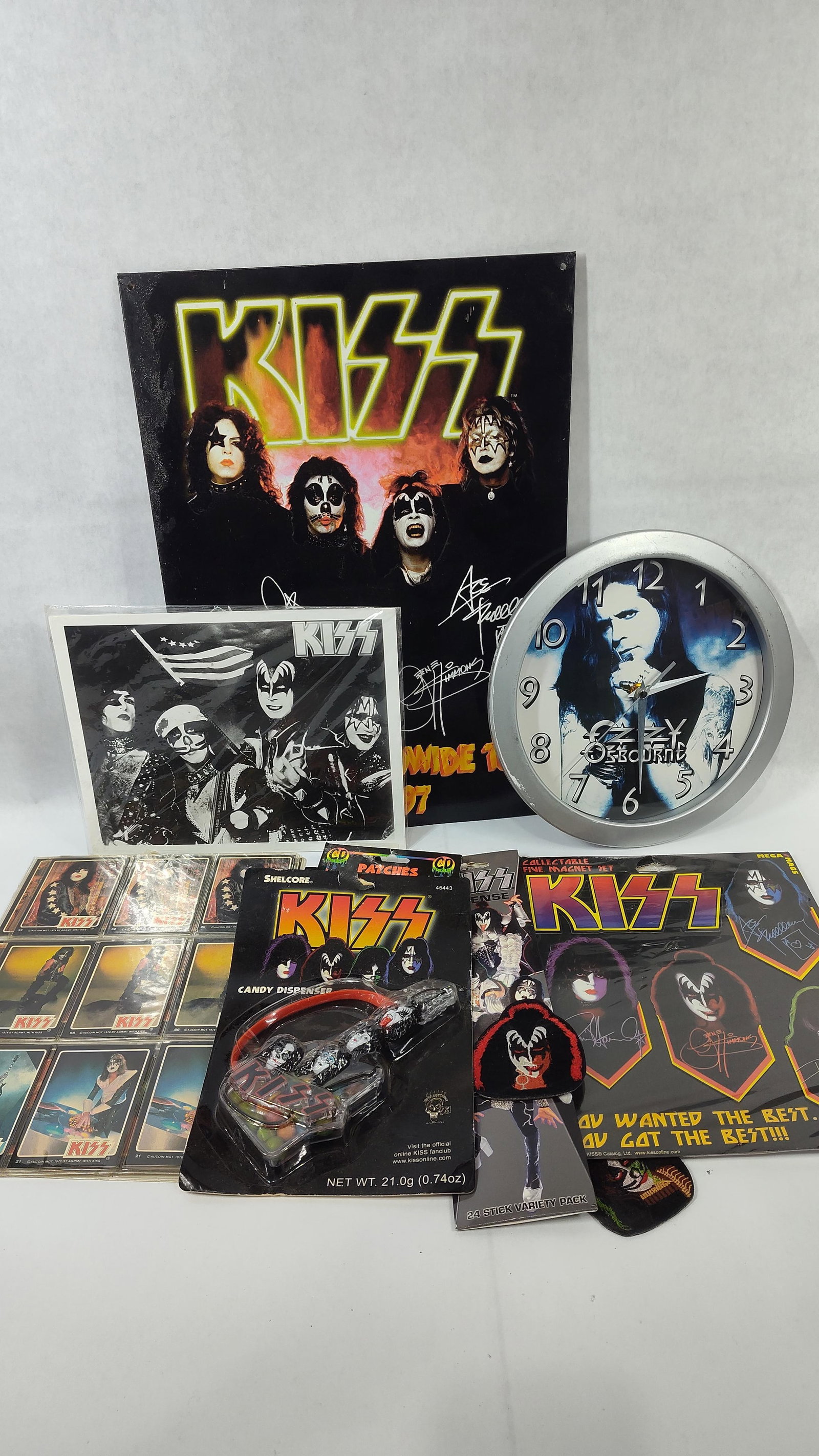 An Assortment of Rock Music Memorabilia Featuring KISS and Ozzy Osbourne: This collection of music memorabilia includes items related to the band KISS and artist Ozzy Osbourne. The lot comprises a promotional sign for the KISS Alive/Worldwide Tour 1996-1997, featuring the o