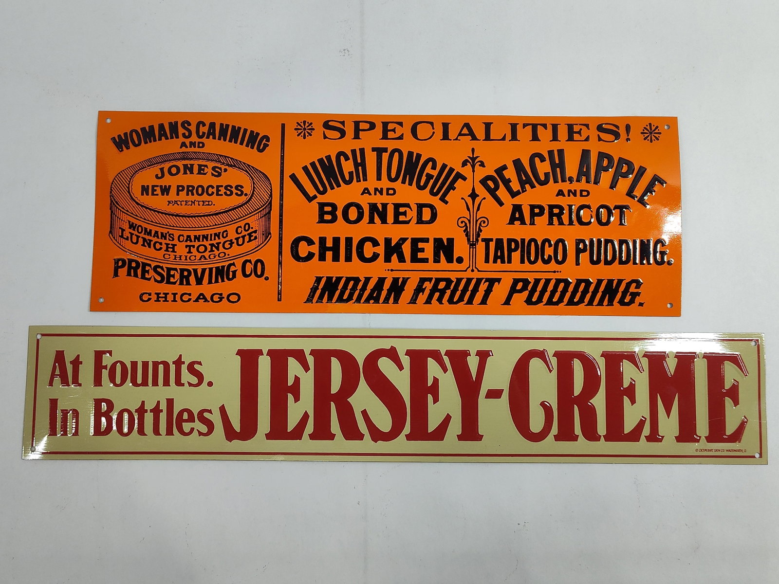 Two Embossed Metal Reproduction Advertising Signs: This lot comprises two embossed metal advertising signs, produced as modern decorative reproductions ofsignage. The first sign features a bright orange field with black embossed graphics for the Woman