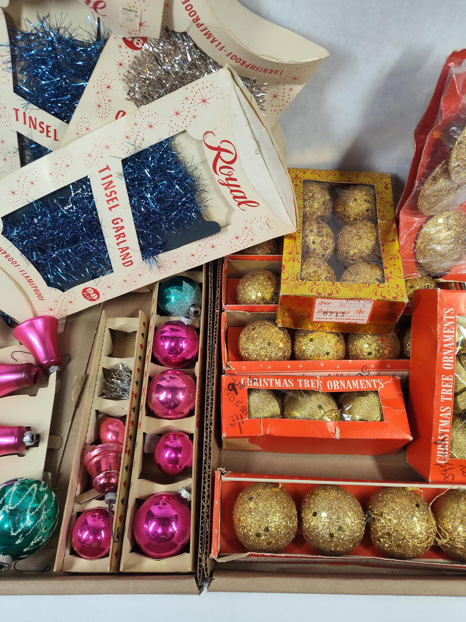 An Assortment ofMid-Century Christmas Ornaments and Tinsel Including Shiny-Brite and Holt-Howard: mid-century holiday decorations comprising various ornaments and garlands. The group includes several packages of Royal brand tinsel garland in blue and silver, housed in original cream and red cardbo