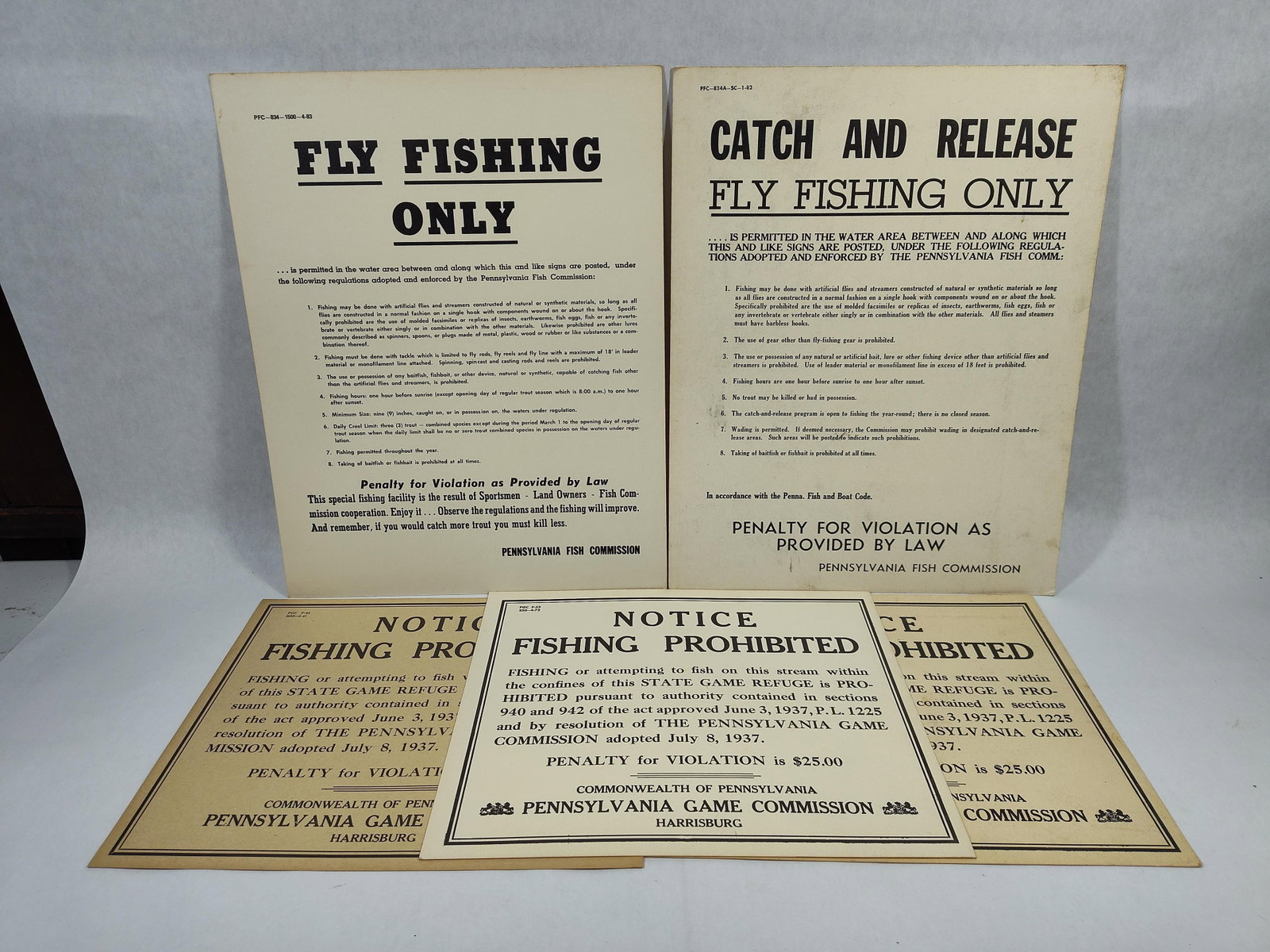 A Group of FivePennsylvania Fishing Regulatory Cardstock Signs: This group of fivesigns printed on cardstock includes regulatory notices issued by the Pennsylvania Fish Commission and the Pennsylvania Game Commission. The collection features two larger format sign