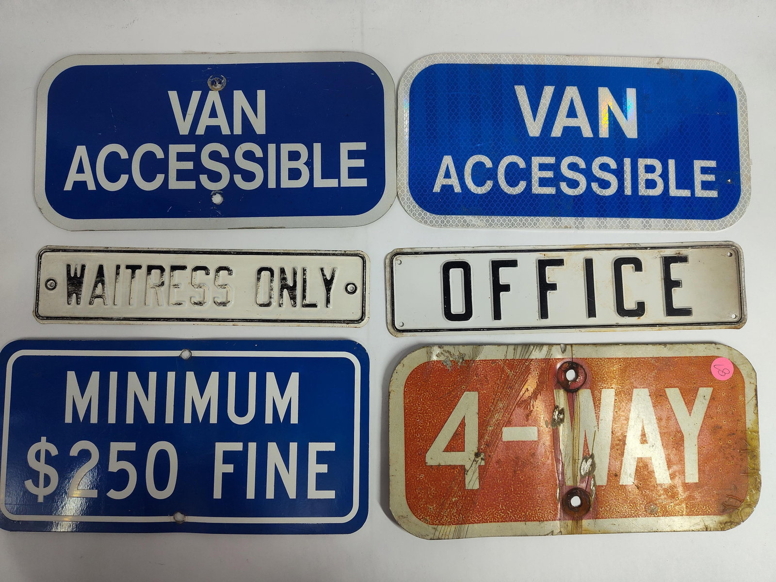Metal Traffic and Facility Informational Signs: An assortment of sixmetal informational and traffic-related signs likely salvaged from commercial or municipal settings. The lot includes three rectangular blue signs with white lettering: two reading