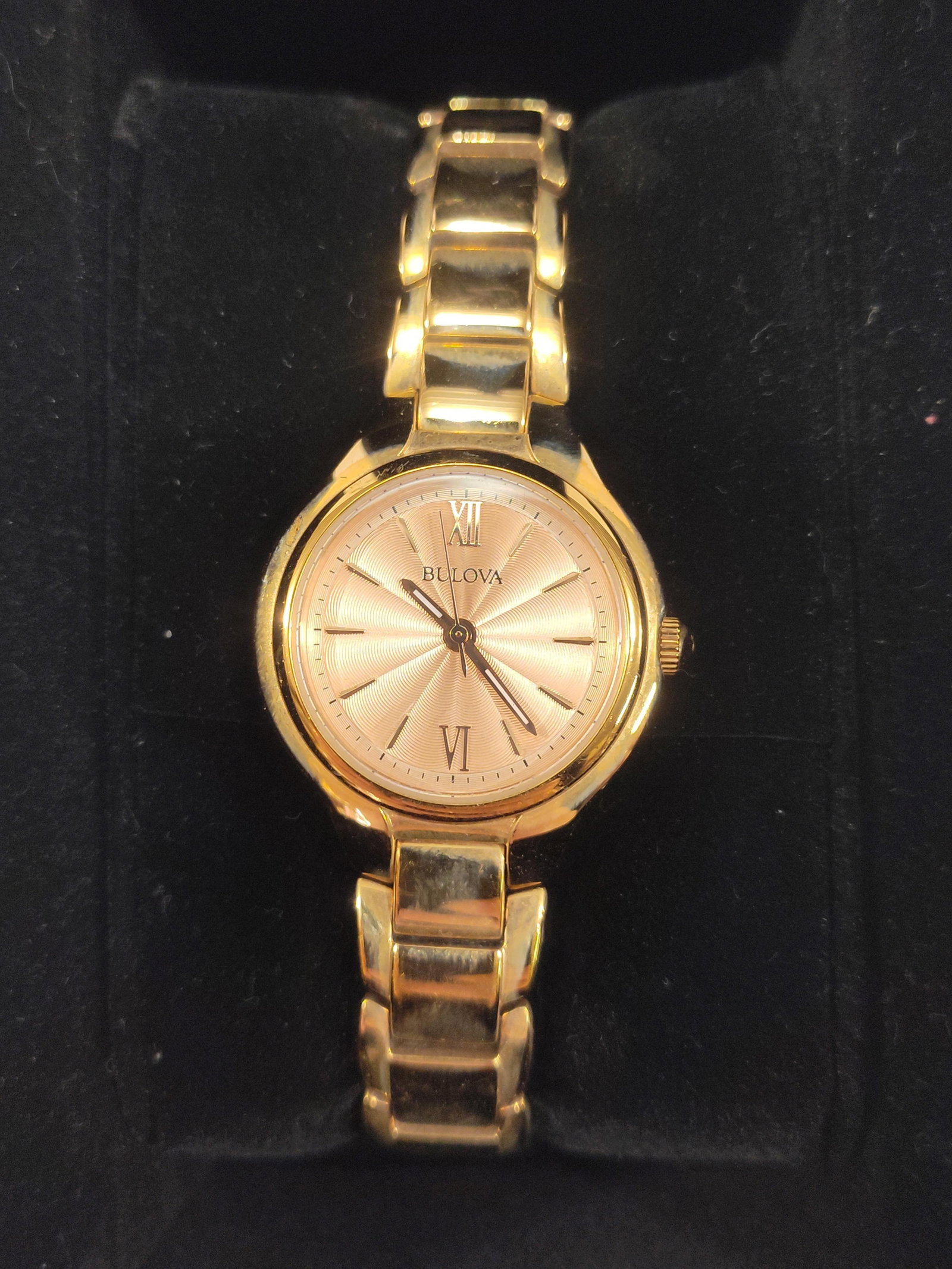 Bulova Ladies' Sutton Rose Gold-Tone Stainless Steel Bracelet Watch: A ladies' dress watch from the Bulova Sutton collection. This timepiece features a rose gold-tone stainless steel case with an integrated polished link bracelet and deployment clasp. The dial is finis