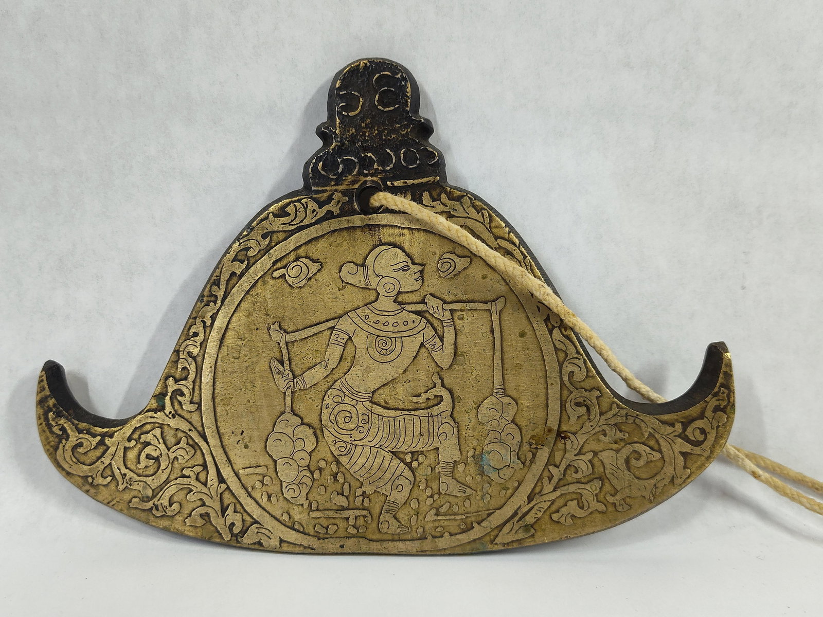 Burmese Engraved Brass Kyizi Gong: This traditional Burmese kyizi, also known as a kye-zee, is a triangular-shaped gong cast from brass. The gong features a flat, crescent-shaped form with flared, upturned ends and a pierced top for su