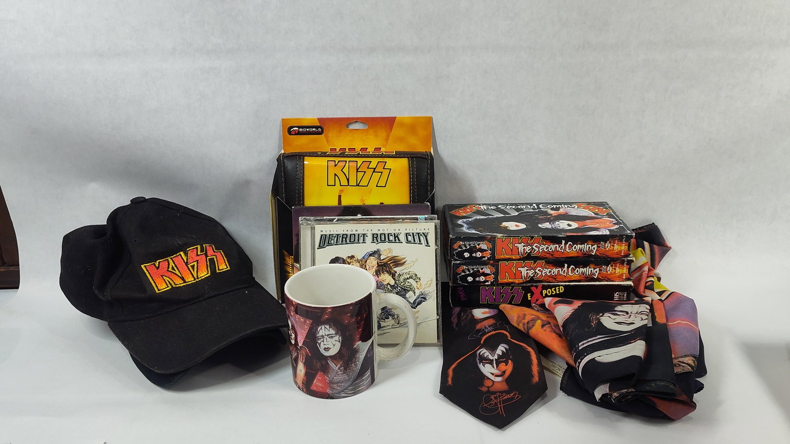 An Assortment of KISS and The Osbournes Rock and Roll Memorabilia: This lot comprises an assortment of rock and roll memorabilia, primarily associated with the band KISS, along with a collectible from The Osbournes. Apparel includes black baseball caps featuring embr