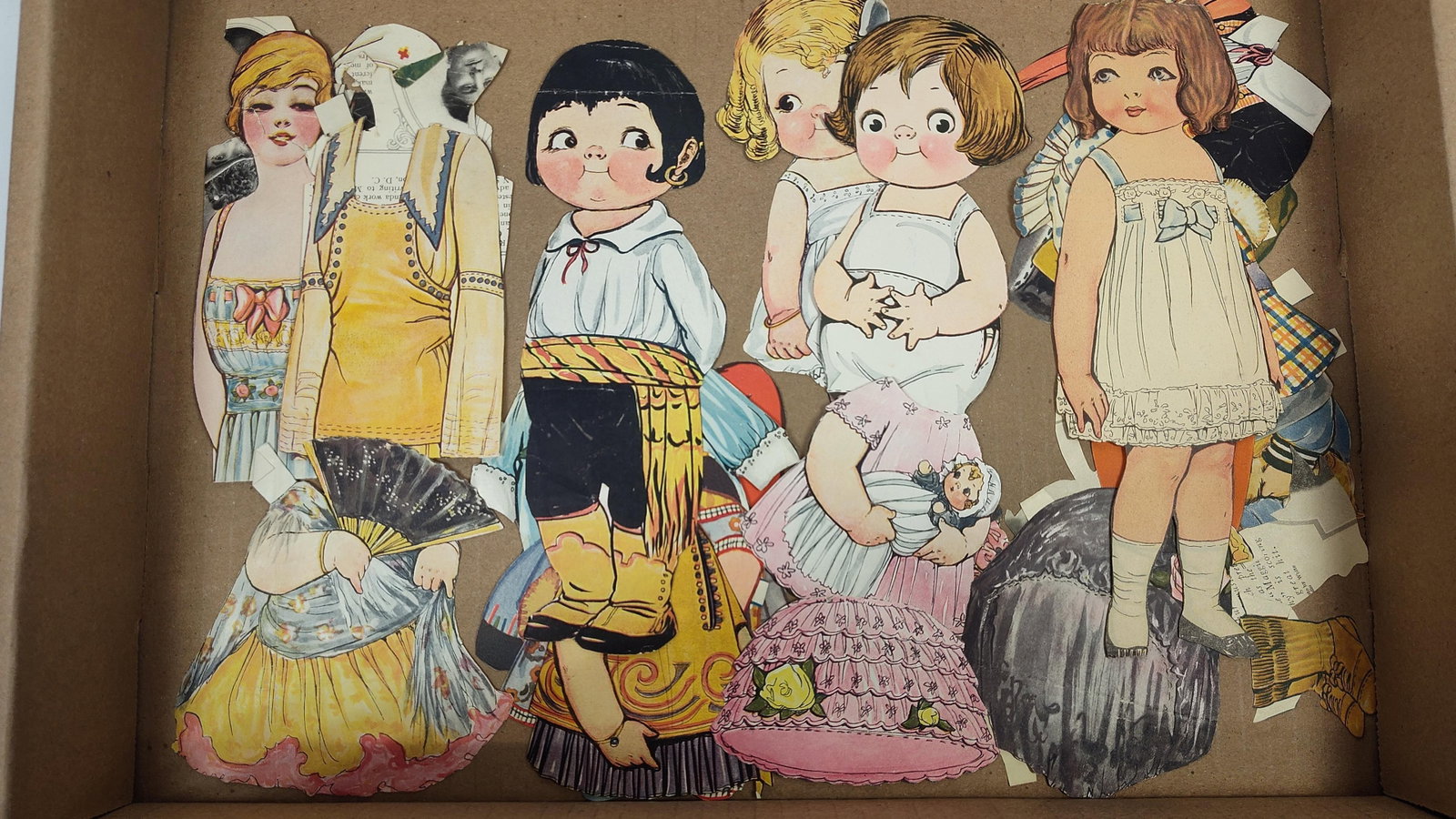 Antique Dolly Dingle Paper Doll Magazine Cutouts Attributed to Grace G. Drayton: This collection consists of multiple hand-cut paper doll figures and associated clothing items characteristic of the Dolly Dingle series illustrated by Grace G. Drayton. The figures feature the artist