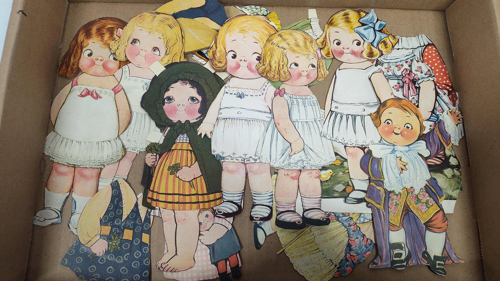 Dolly Dingle Die-Cut Paper Dolls and Outfits attributed to Grace Drayton: This collection of Dolly Dingle die-cut paper dolls and paper clothing is attributed to illustrator Grace G. Drayton. The lot consists of several figures featuring the artist's signature wide-eyed, si
