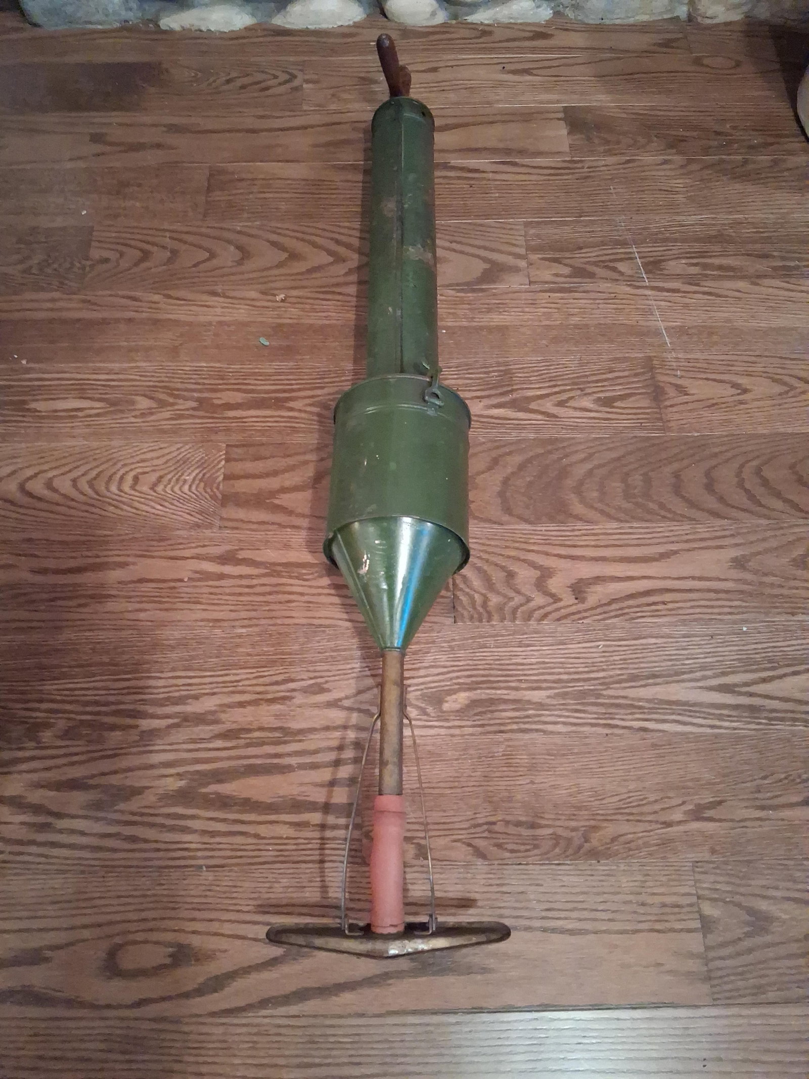 U.S. Steel Stamping Co. National Suction Vacuum: This is an antique manually-operated suction vacuum cleaner manufactured by the U.S. Steel Stamping Co. The tool features a long cylindrical body finished in green paint, leading to a central