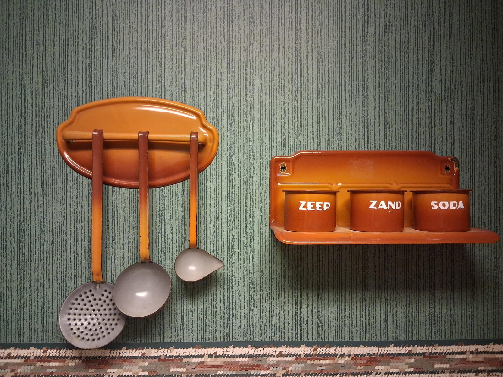 Pair Dutch Shaded Orange Enamel Kitchen Organizers: This lot features two vintage wall-mounted kitchen organization units, designed for the Dutch or Belgian market. Both pieces are constructed from pressed steel finished in a traditional shaded or