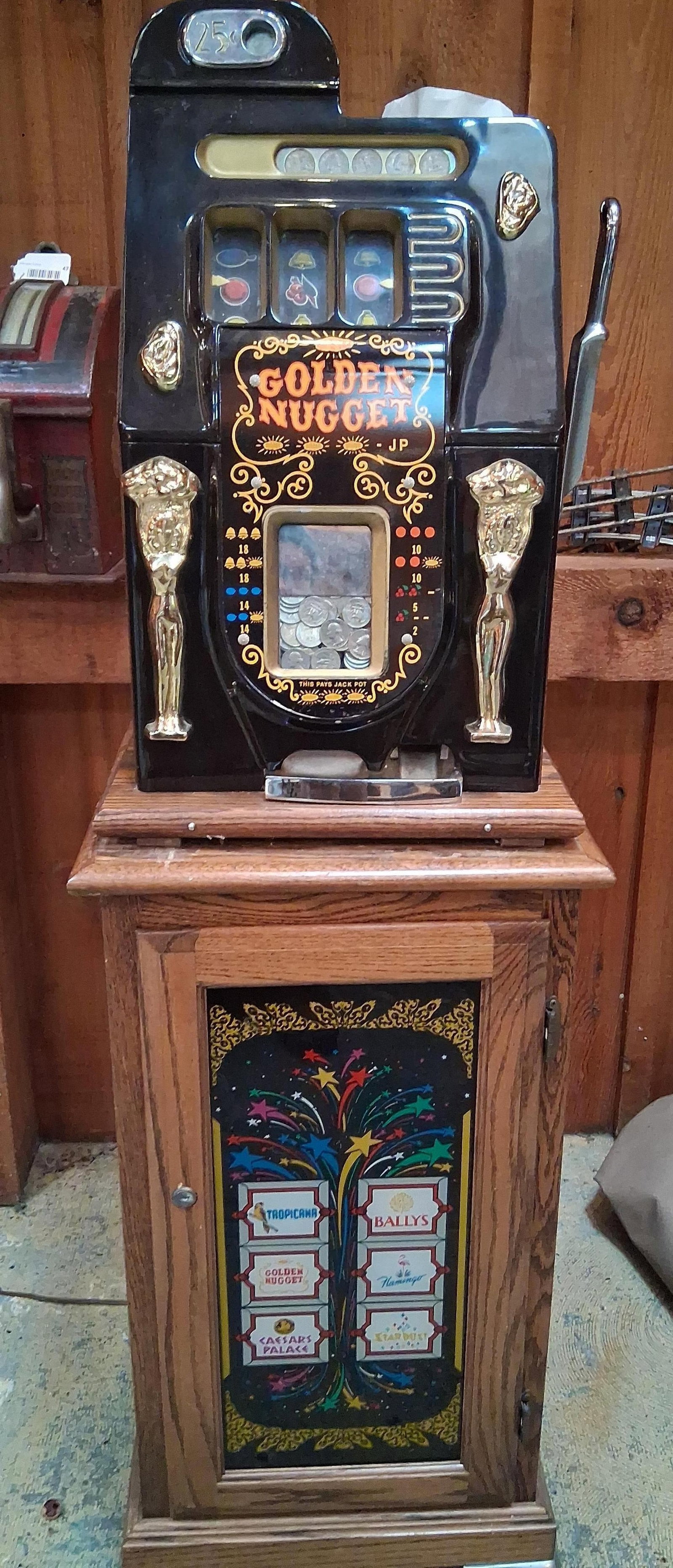 Mills 25 Cent Golden Nugget Slot Machine on Stand: has not been used in a while. Has key. Would not take much to clean up and get working. A Mills Novelty Company mechanical three-reel slot machine, 25-cent denomination, featuring the Golden Nugget