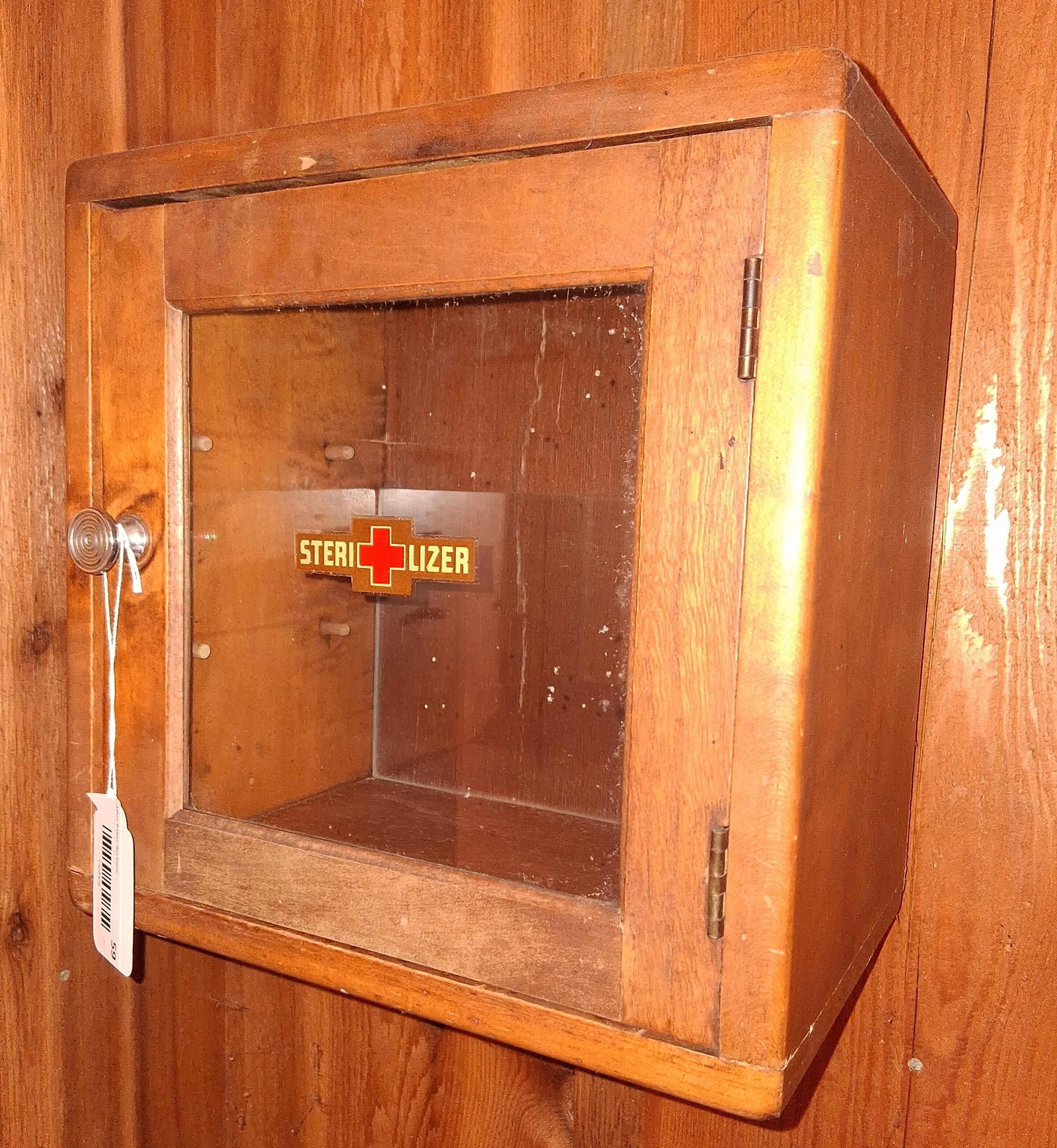 Antiseptic Sterilizer Cabinet: 12x8x12. This vintage wall-mounted antiseptic sterilizer cabinet is constructed from solid hardwood with a warm, medium-toned finish and rounded exterior corners. The front-opening door is fitted with