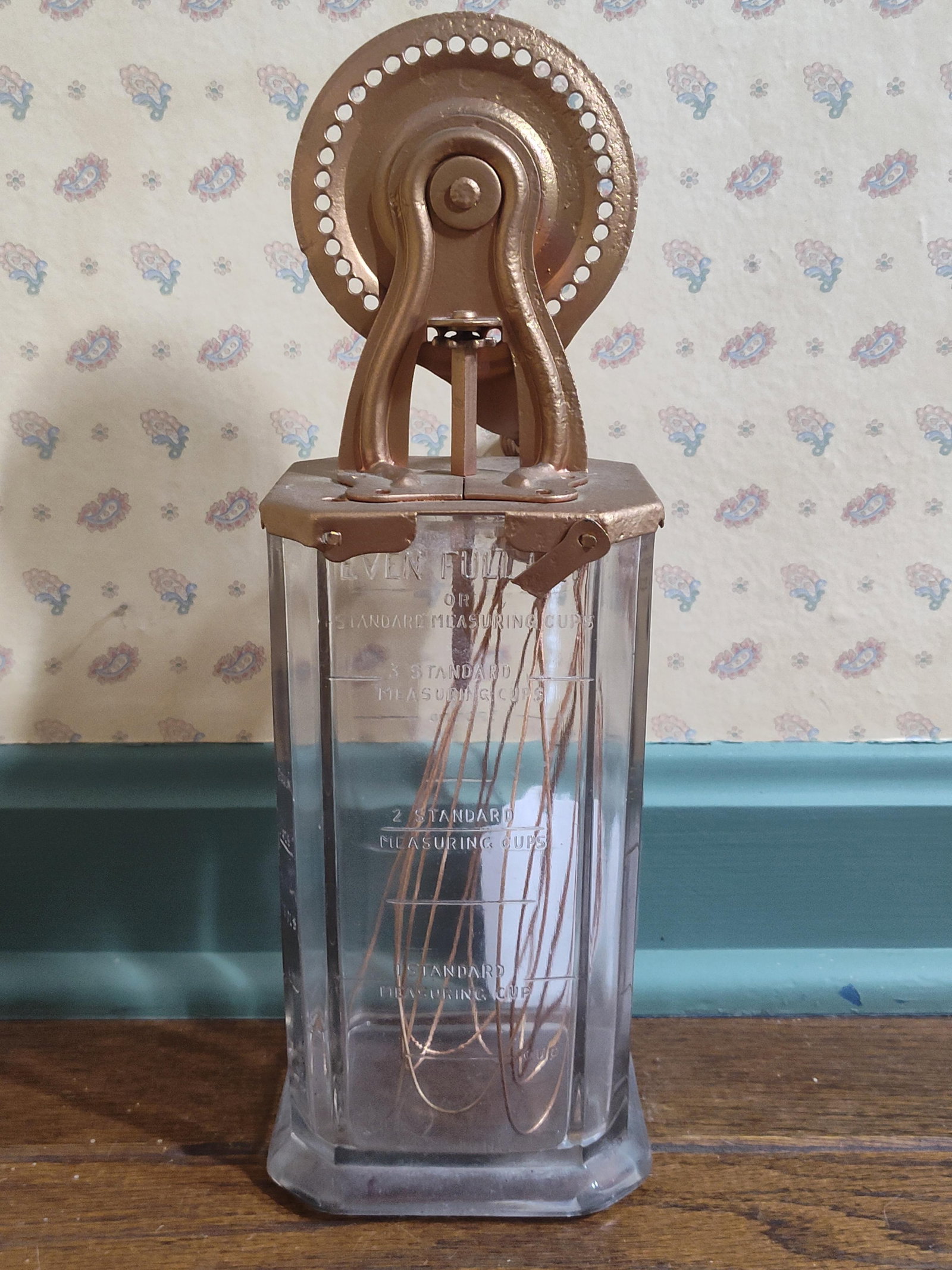 Hazel-Atlas Glass Measuring Jar w/ A & J Beater: This lot features a manual kitchen mixer set consisting of a clear pressed-glass measuring vessel and a matching mechanical beater. The jar is designed with a square-sided body and an octagonal