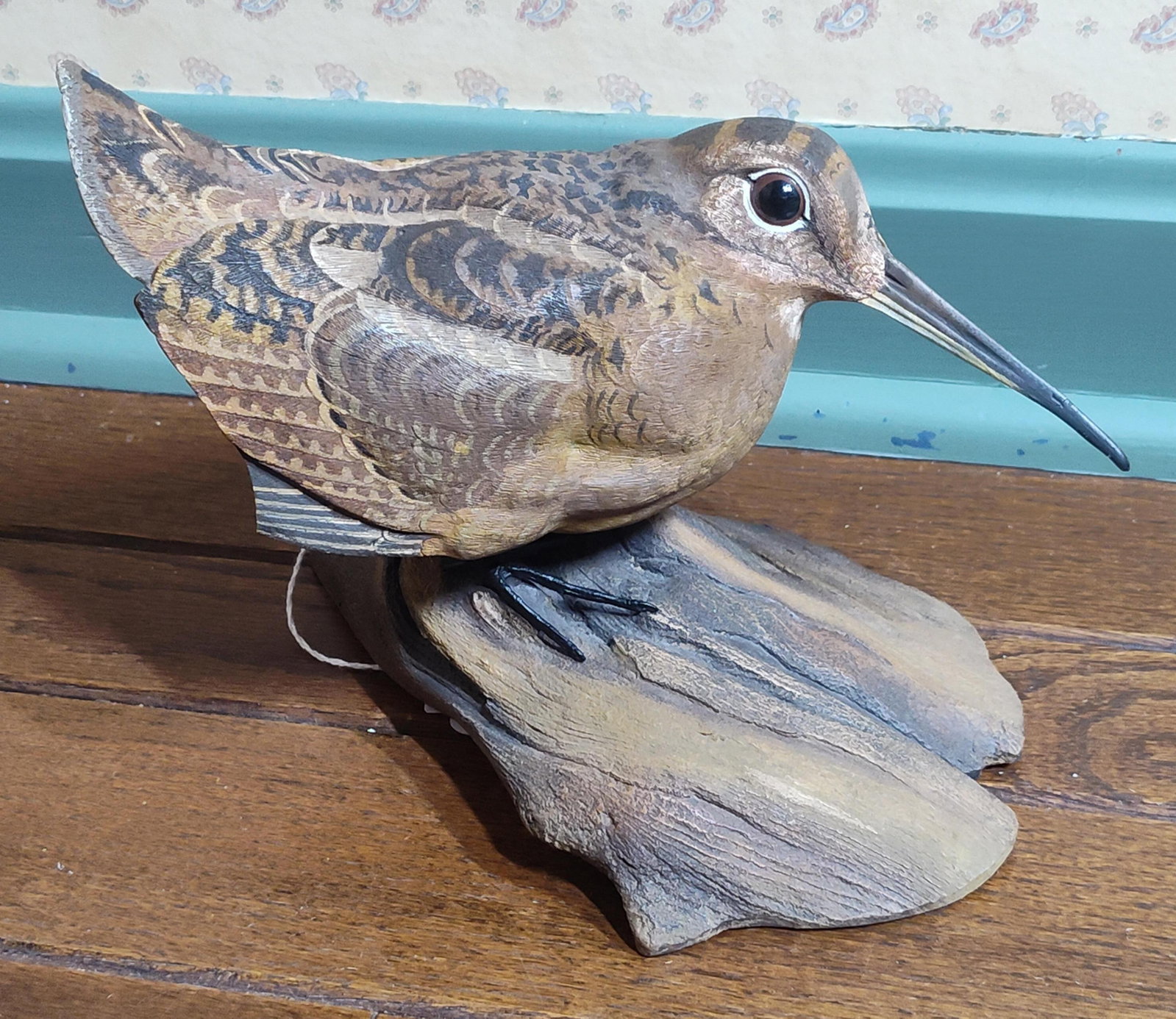 Ernest Muehlmatt American Woodcock Figurine, 1983: This hand-painted figurine depicts an American Woodcock in a perched position upon a naturalistic base modeled to resemble a weathered log. The bird features realistic anatomical details including a