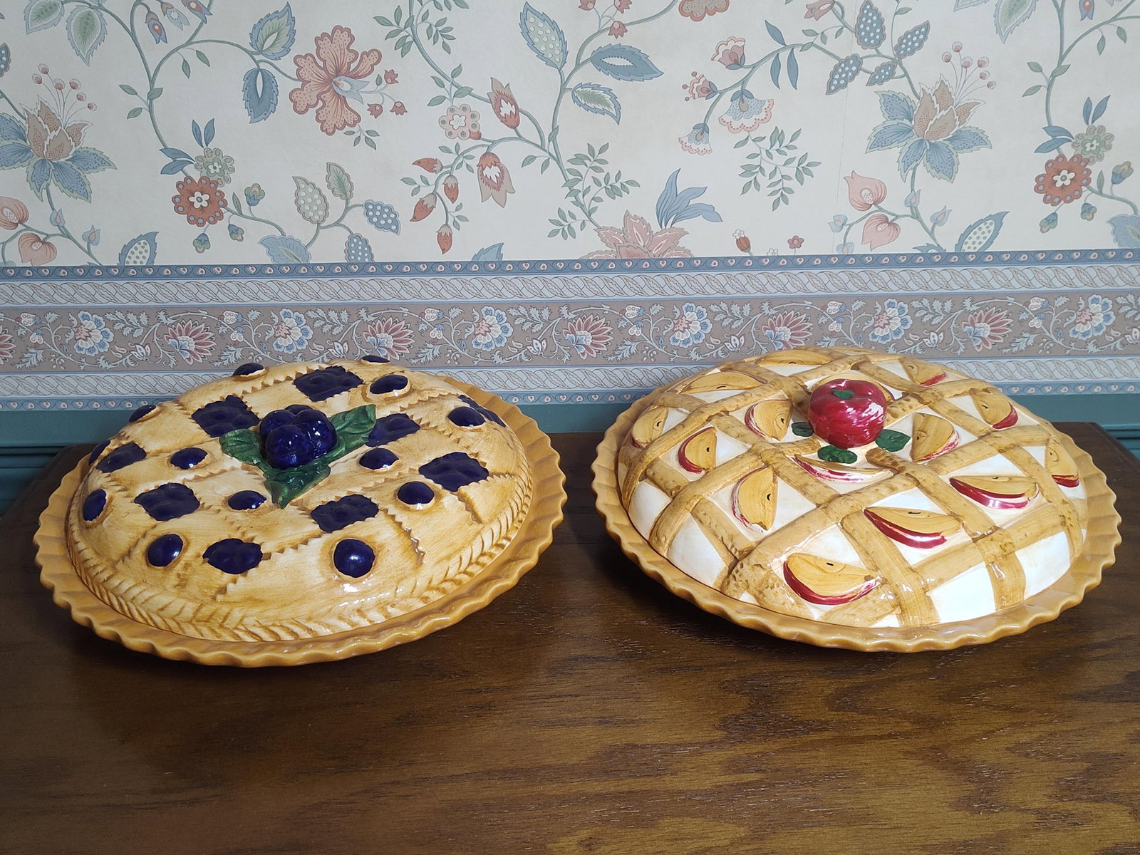 A Pair of Glazed Earthenware Covered Pie Dishes: A pair of decorative glazed earthenware covered pie dishes. Each set consists of a circular base dish with a deep mustard yellow glaze and a fluted, crimped rim, paired with a highly dimensional,