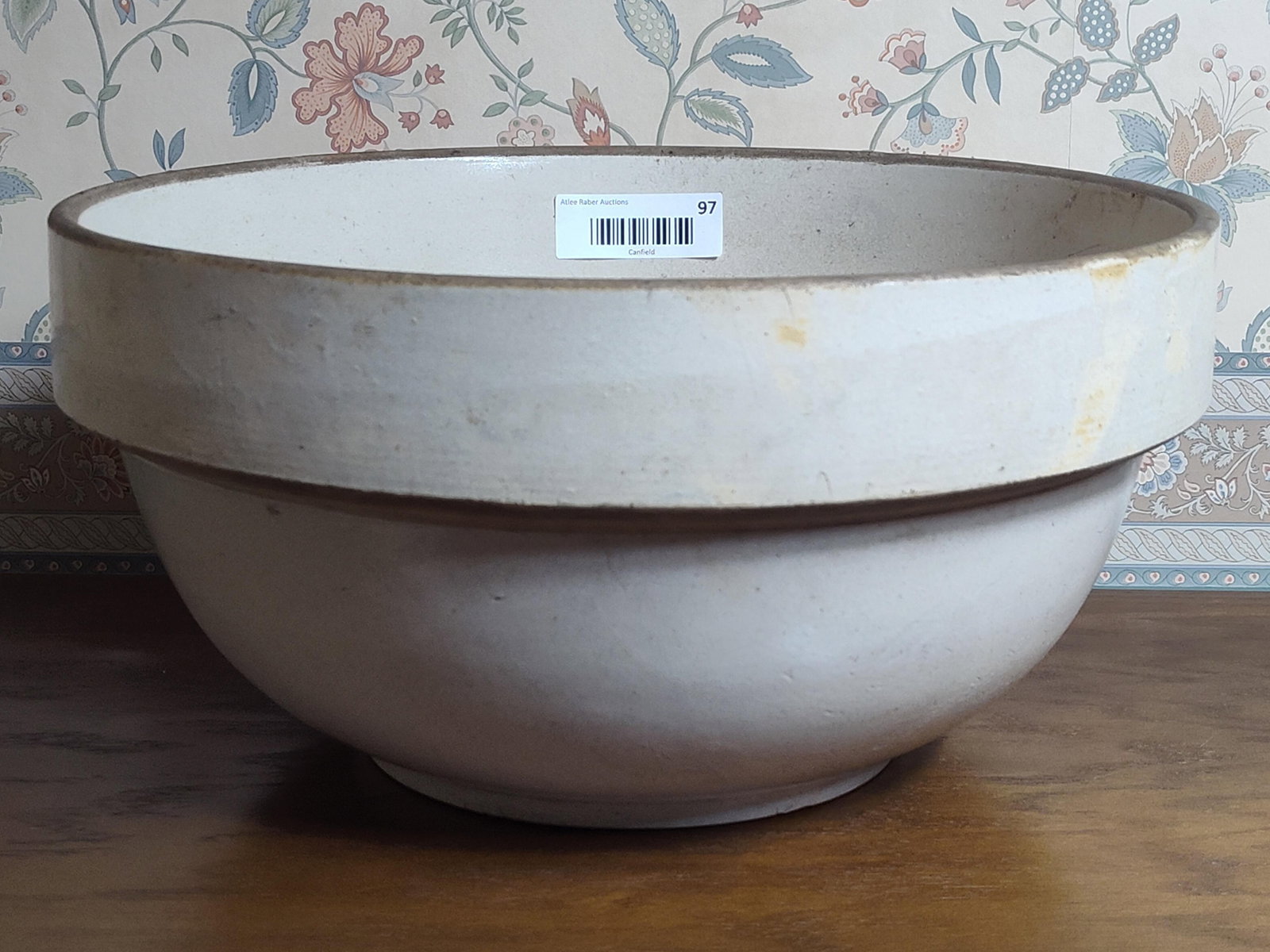 Stoneware Dairy Mixing Bowl w/ Wide Collar Rim: This large American utilitarian stoneware mixing bowl, frequently used as a bread dough or milk bowl in farmhouse settings, features a deep body that tapers toward a flat, circular base. The vessel