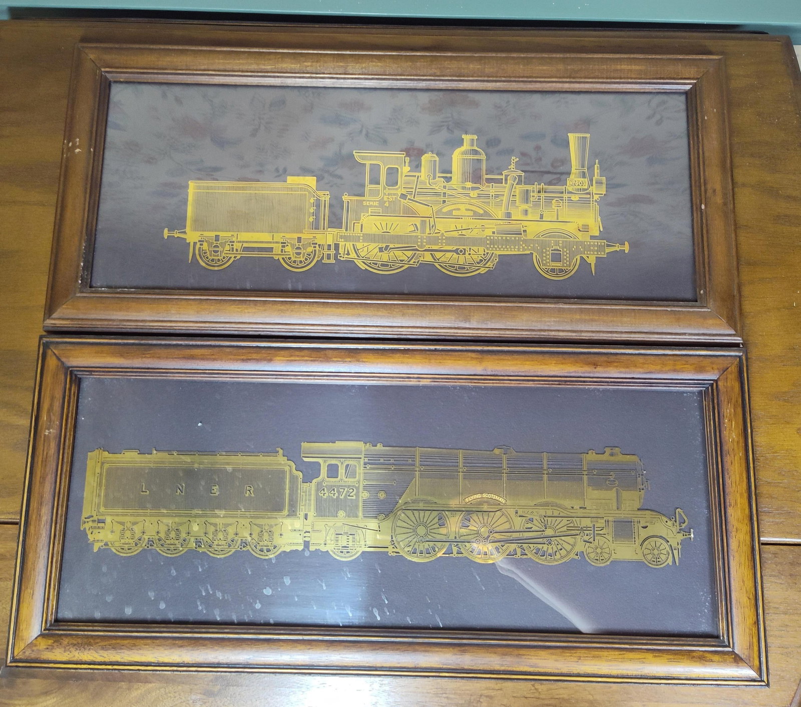 Pair Franklin Mint Gold on Str. Train Silhouettes: A pair of metallic silhouette artworks produced by The Franklin Mint in collaboration with the National Railway Museum, depicting the historic steam locomotives The Orient Express and The Flying