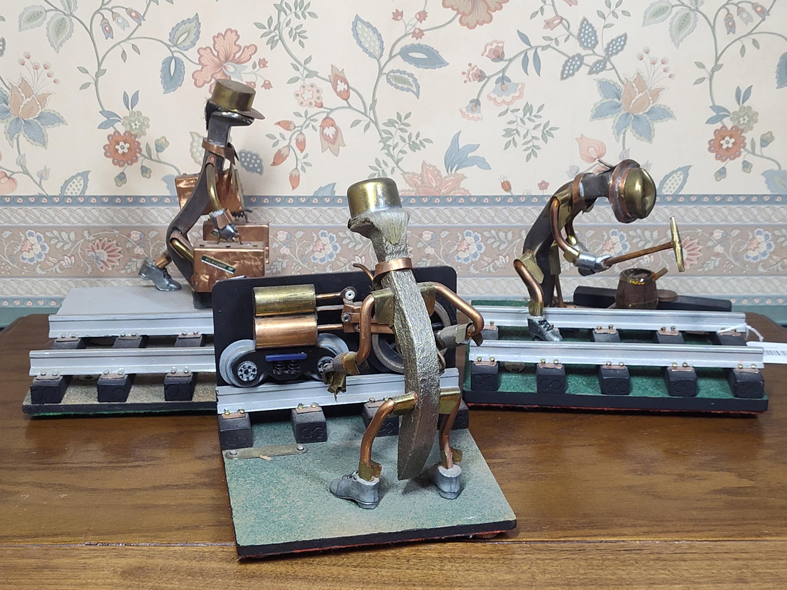 3 Emil J. Turek Railroad Spike Folk Art Sculptures: A trio of folk art sculptures by Emil J. Turek, constructed from found objects and railroad hardware. Each figure features a bent railroad spike torso and head, with limbs and accessories fashioned