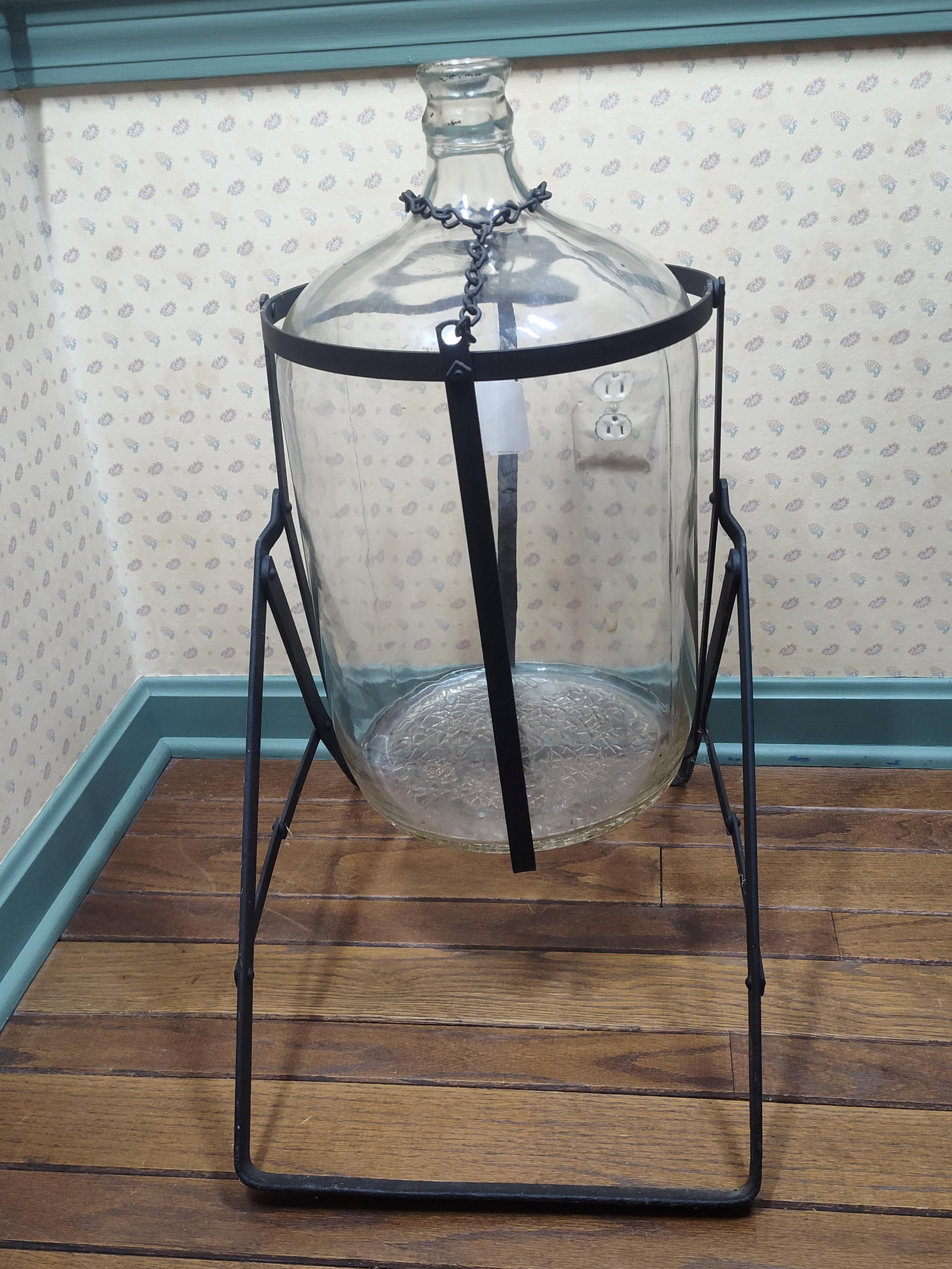Large Glass Carboy in Metal Tilting Pouring Stand: A large clear glass carboy, attributed to manufacturers such as Crisa or Illinois Glass, featuring a distinctive crackle glass textured base. The cylindrical vessel is designed with rounded shoulders