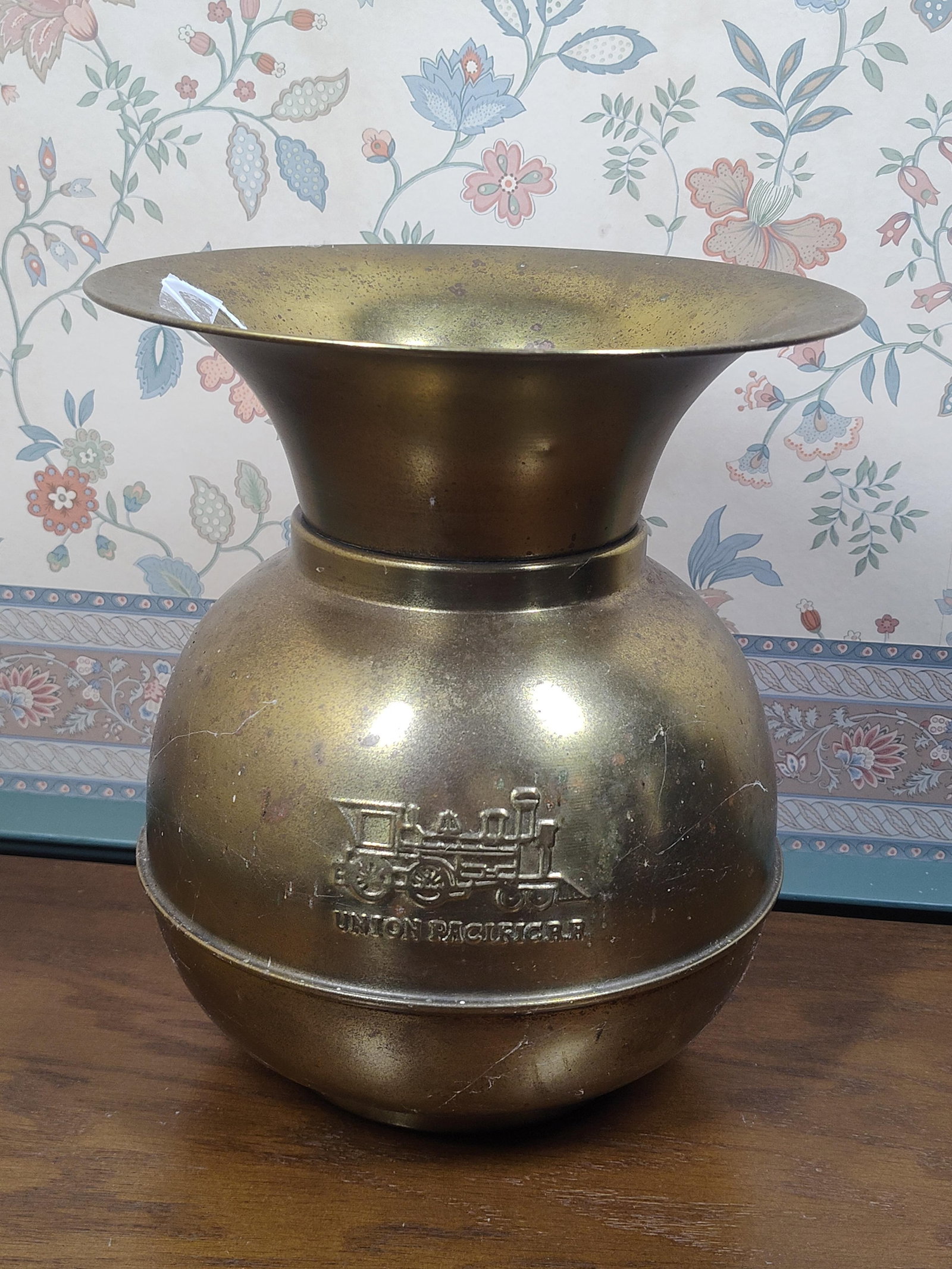 Union Pacific Railroad Locomotive Spittoon: This spittoon is a vintage transportation collectible featuring Union Pacific Railroad branding. The vessel is constructed from brass and follows a traditional cuspidor form with a wide, flared