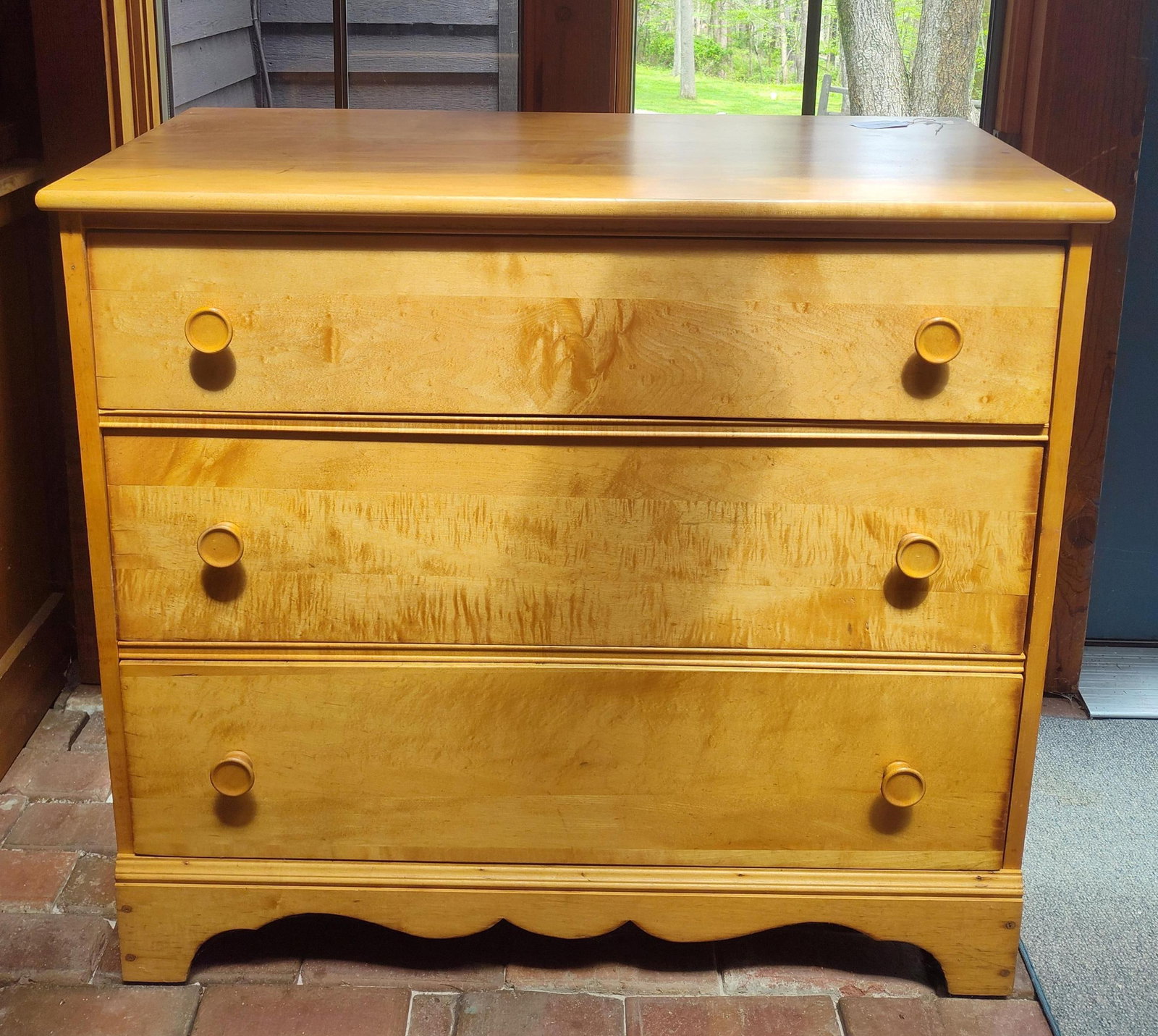Colonial Revival Curly Maple Three Drawer Chest: A mid 20th century American Colonial Revival style chest of drawers featuring a solid wood construction. The case is fitted with three full width drawers, each notable for the prominent figure of