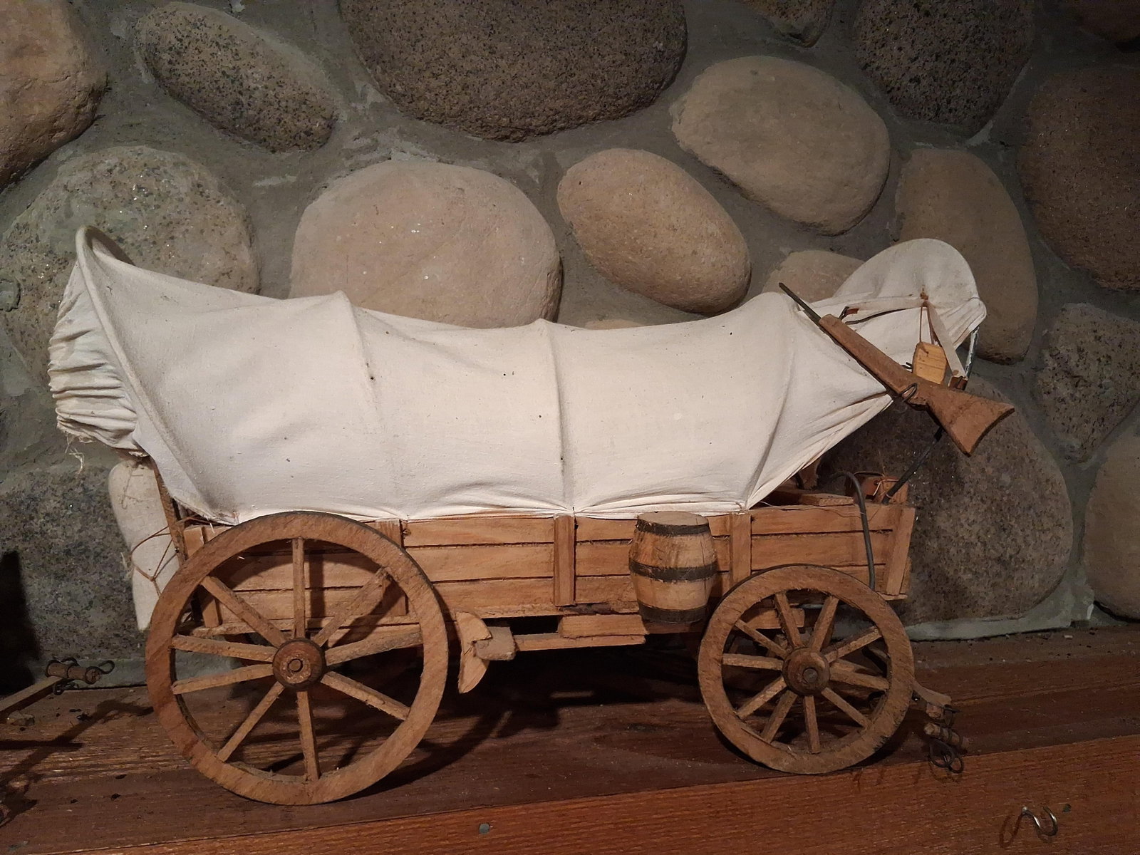Vtg Pioneer Style Covered Wagon Model: This is a detailed scale model of a pioneer-style covered wagon, constructed in the style of those used during the American westward expansion. The model is primarily constructed of wood with a