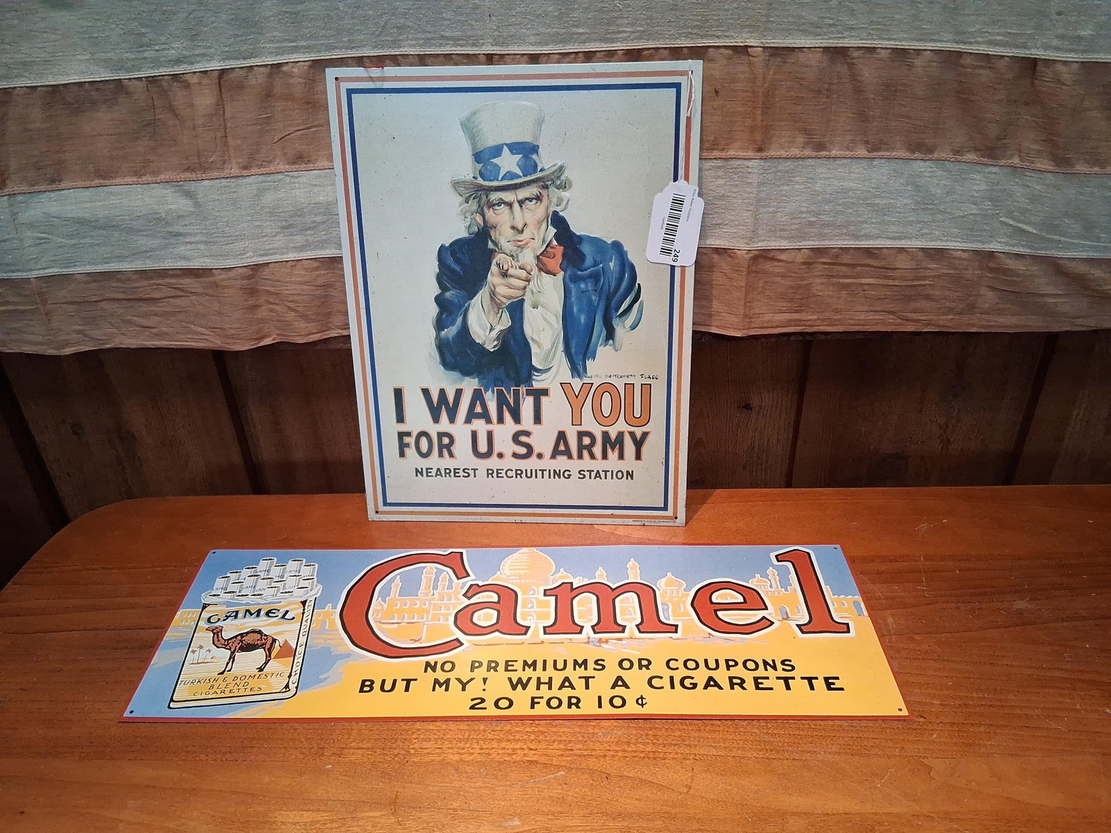 Pair Metal Uncle Sam & Camel Advertising Signs: This lot features two metal advertising signs. The first is an embossed tin sign manufactured by Desperate Sign Co. in Wadsworth, Ohio, which reproduces the iconic James Montgomery Flagg Uncle Sam I