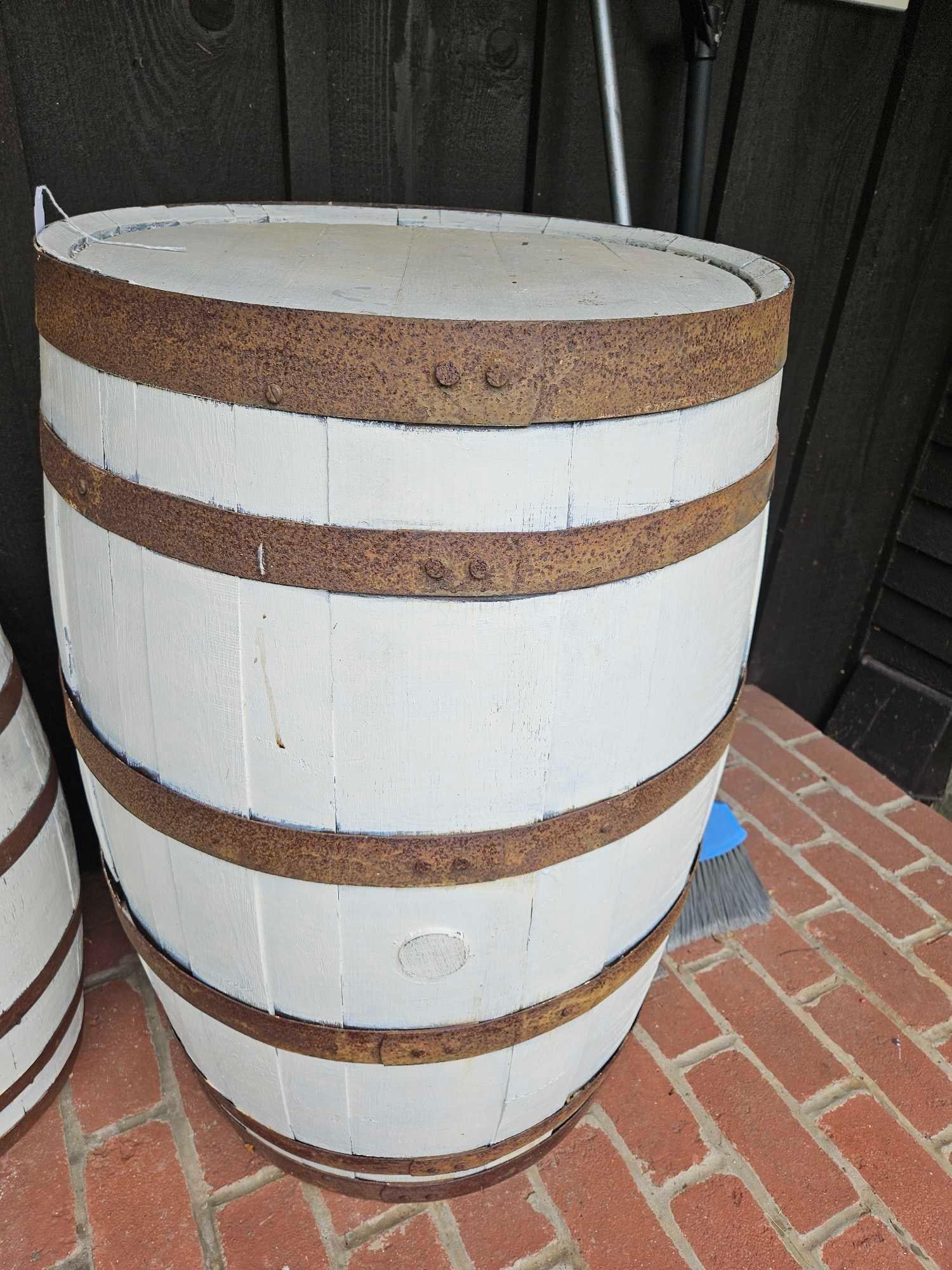 White Painted Oak Whiskey Barrel: 34 inches tall. Decorative barrel is constructed from oak staves in a traditional cooperage style. Each barrel features five horizontal metal hoops that exhibit heavy surface oxidation and rust. Both