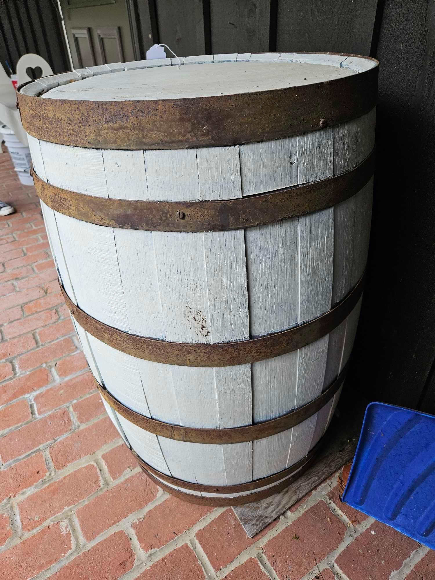 White Painted Oak Whiskey Barrel: 23 inches tall. Decorative barrel is constructed from oak staves in a traditional cooperage style. Each barrel features five horizontal metal hoops that exhibit heavy surface oxidation and rust. Both