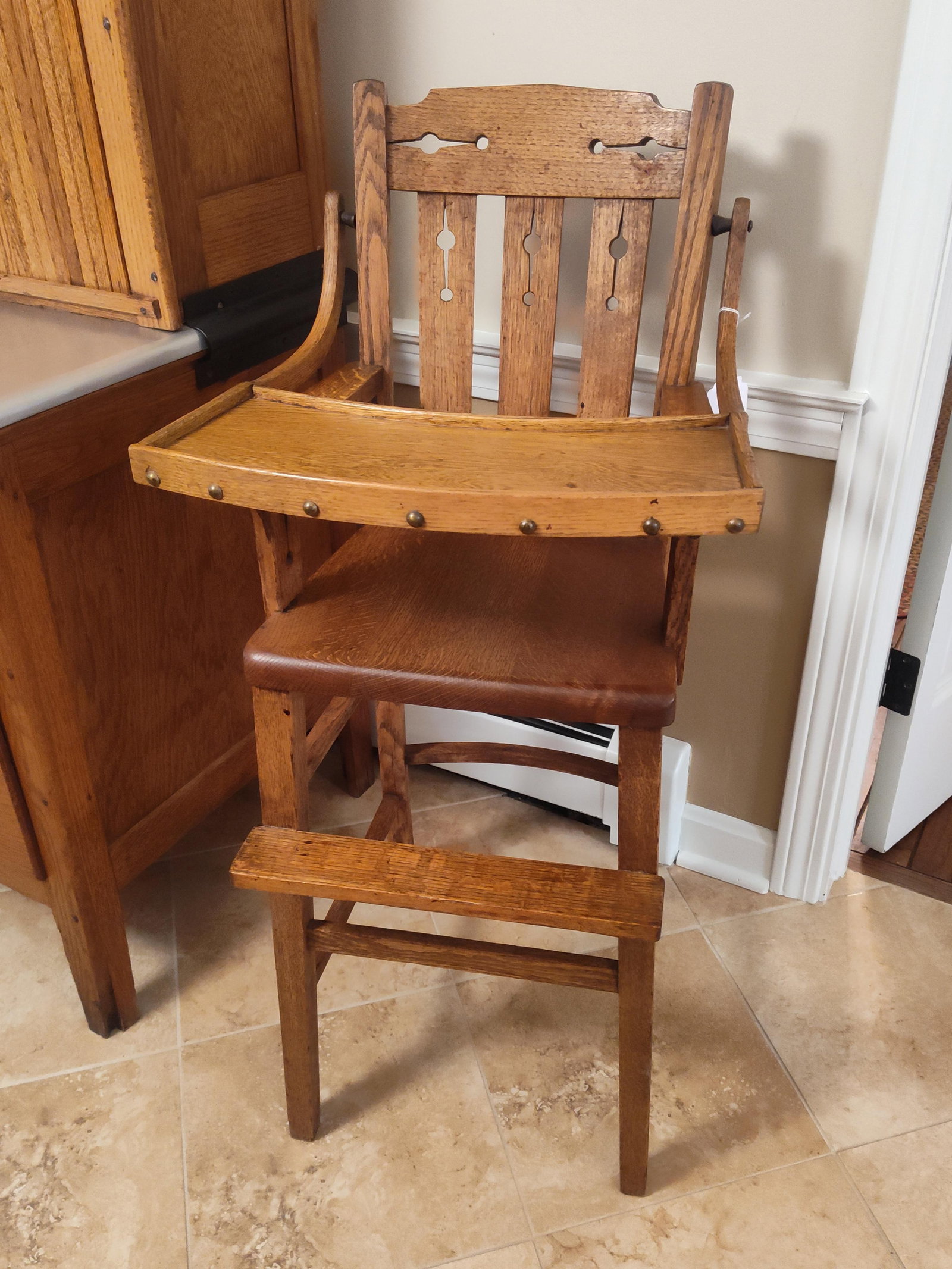 American Arts & Crafts Quarter-Sawn Oak High Chair: This antique child's high chair is constructed from solid quarter-sawn white oak, commonly referred to as tiger oak due to the prominent and decorative medullary ray patterns visible in the grain. The