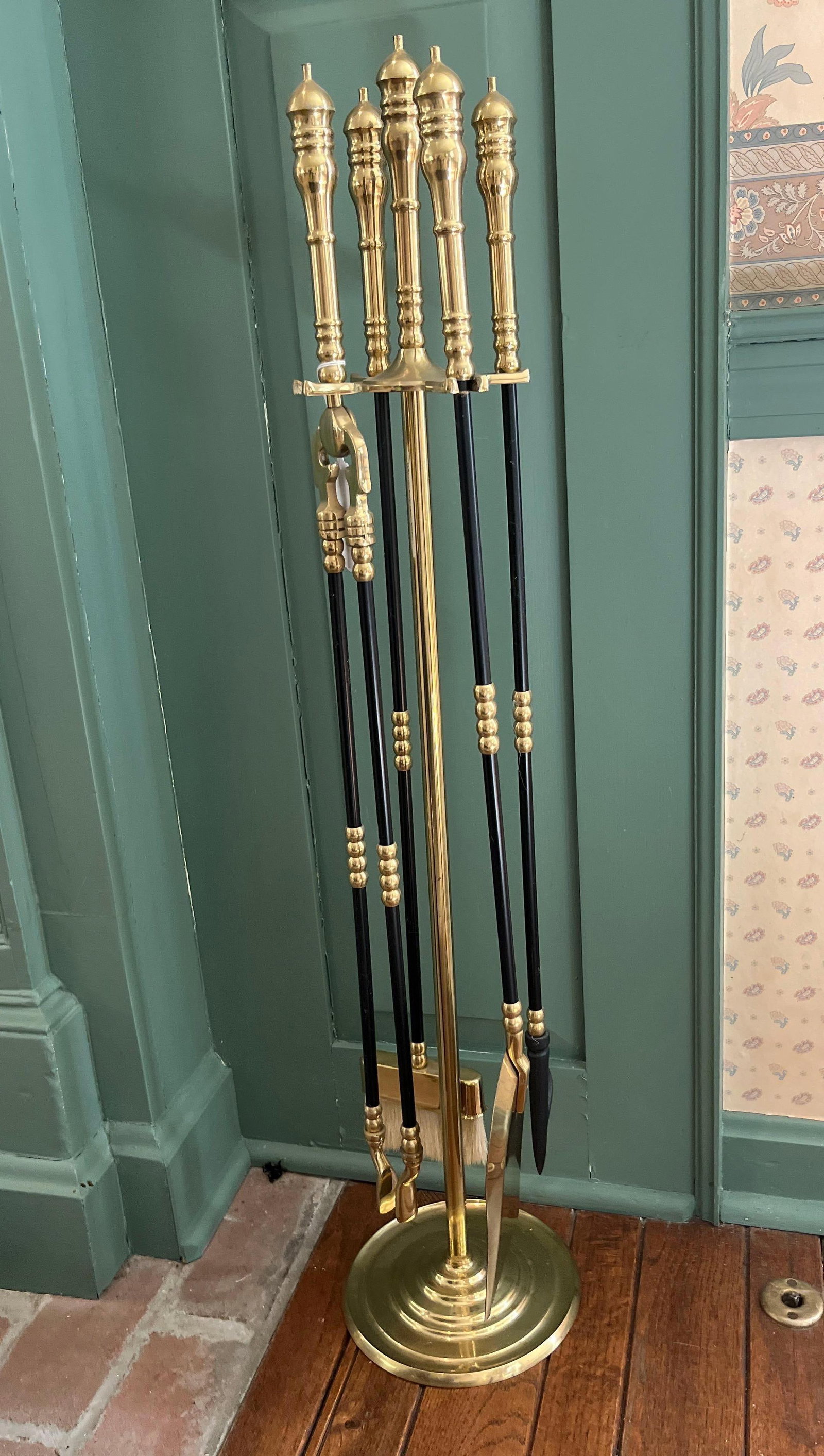 Set 5 Brass & Black Metal Fireplace Tools on Stand: This set of fireplace equipment consists of a central stand, a shovel, a pair of tongs, a poker, and a natural fiber brush. The tools are designed in a traditional American Colonial style, featuring