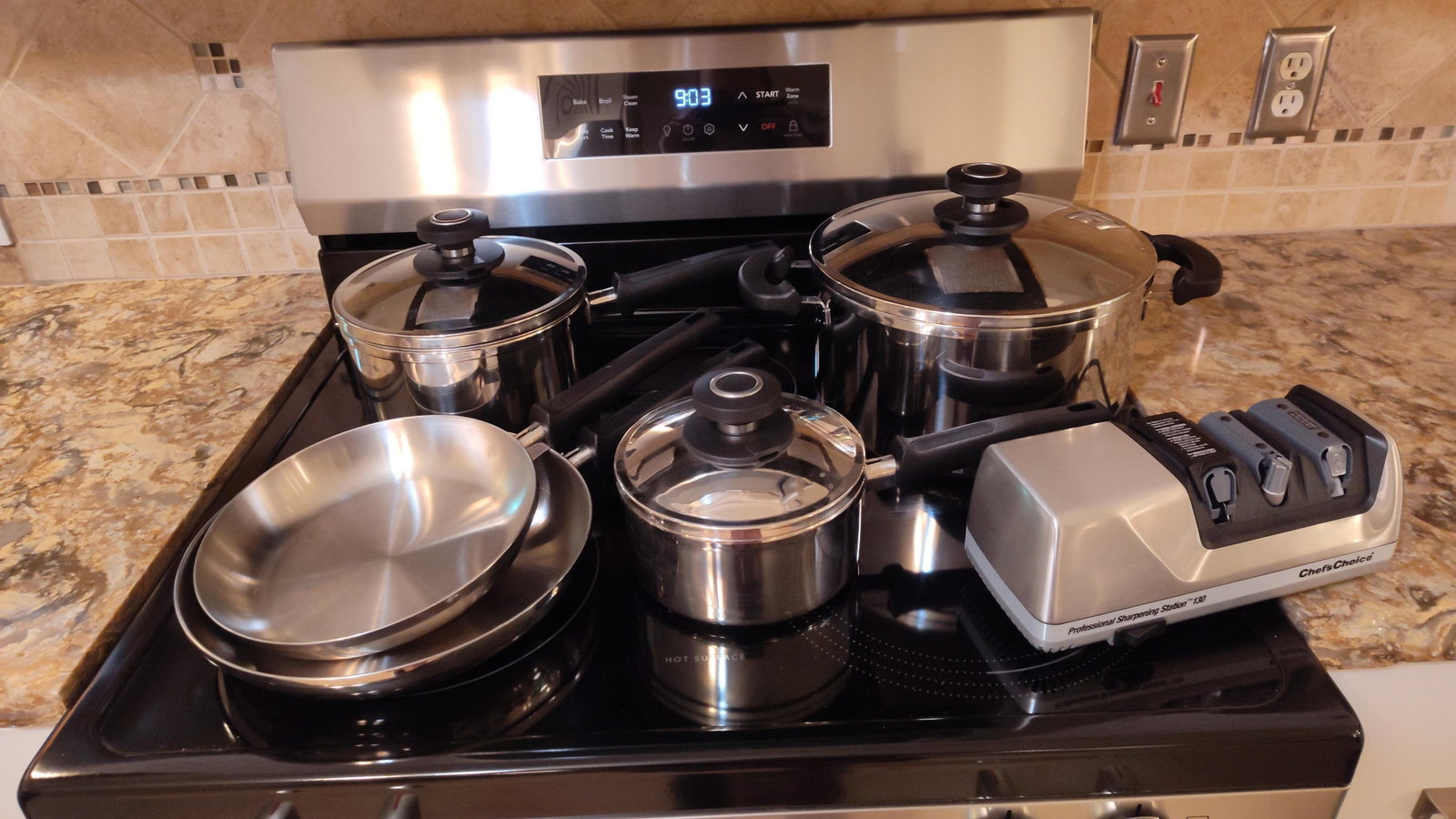 Magnalite Cookware & Chef'sChoice Sharpener: This lot features a set of stainless steel cookware from the Magnalite Classic line alongside a professional electric knife sharpener. The cookware set includes a large stockpot with twin loop