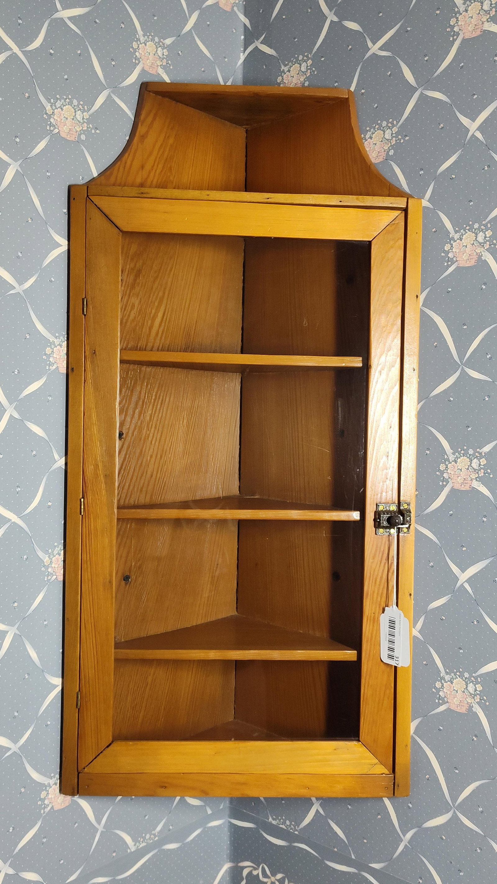 Vintage Pine Wall-Hanging Glazed Corner Cupboard: 37x 17. A vintage one-piece wall-mounted corner cupboard constructed of pine with a warm honey-colored finish. The piece is designed in the Early American or Colonial Revival style, featuring a