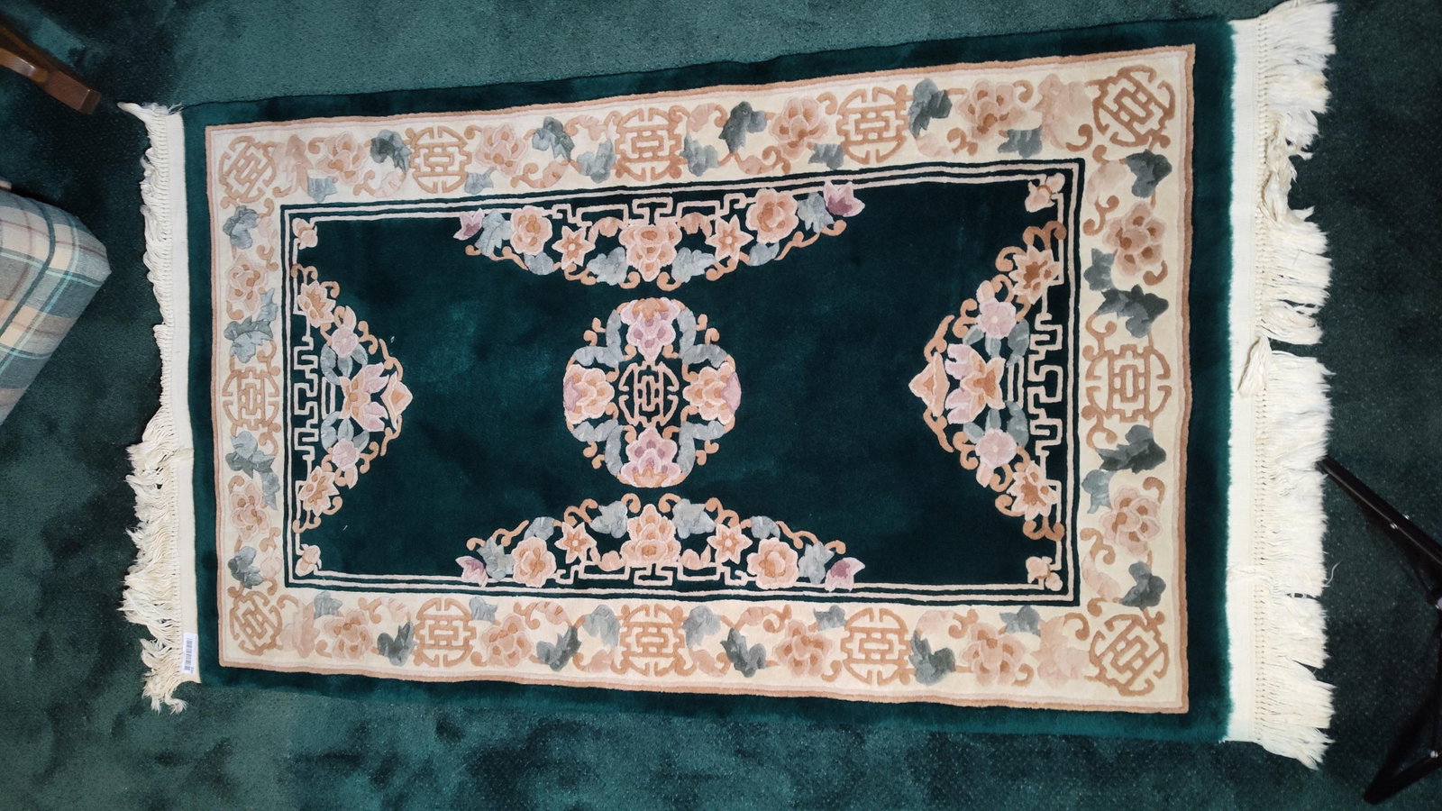 Chinese Art Deco Hand Knotted Sculpted Wool Rug: A Chinese Art Deco style area rug featuring a hand-knotted wool pile on a cotton foundation. The rug is designed with a deep forest green central field anchored by a central floral medallion. Four flo