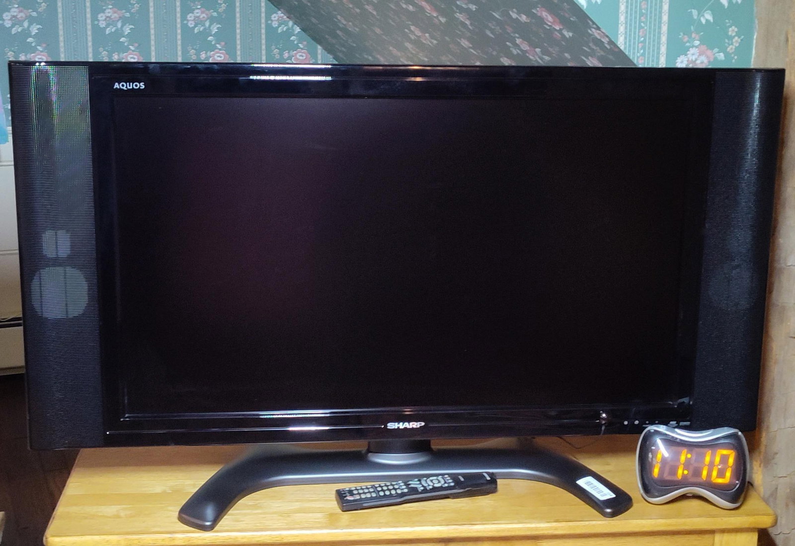 37 in Sharp AQUOS LCD TV & Toshiba DVD/VCR Combo: This group of home electronics consists of a television, a media player, and a digital alarm clock. The television is a Sharp AQUOS flat-panel LCD model, approximately 32 inches measured diagonally.