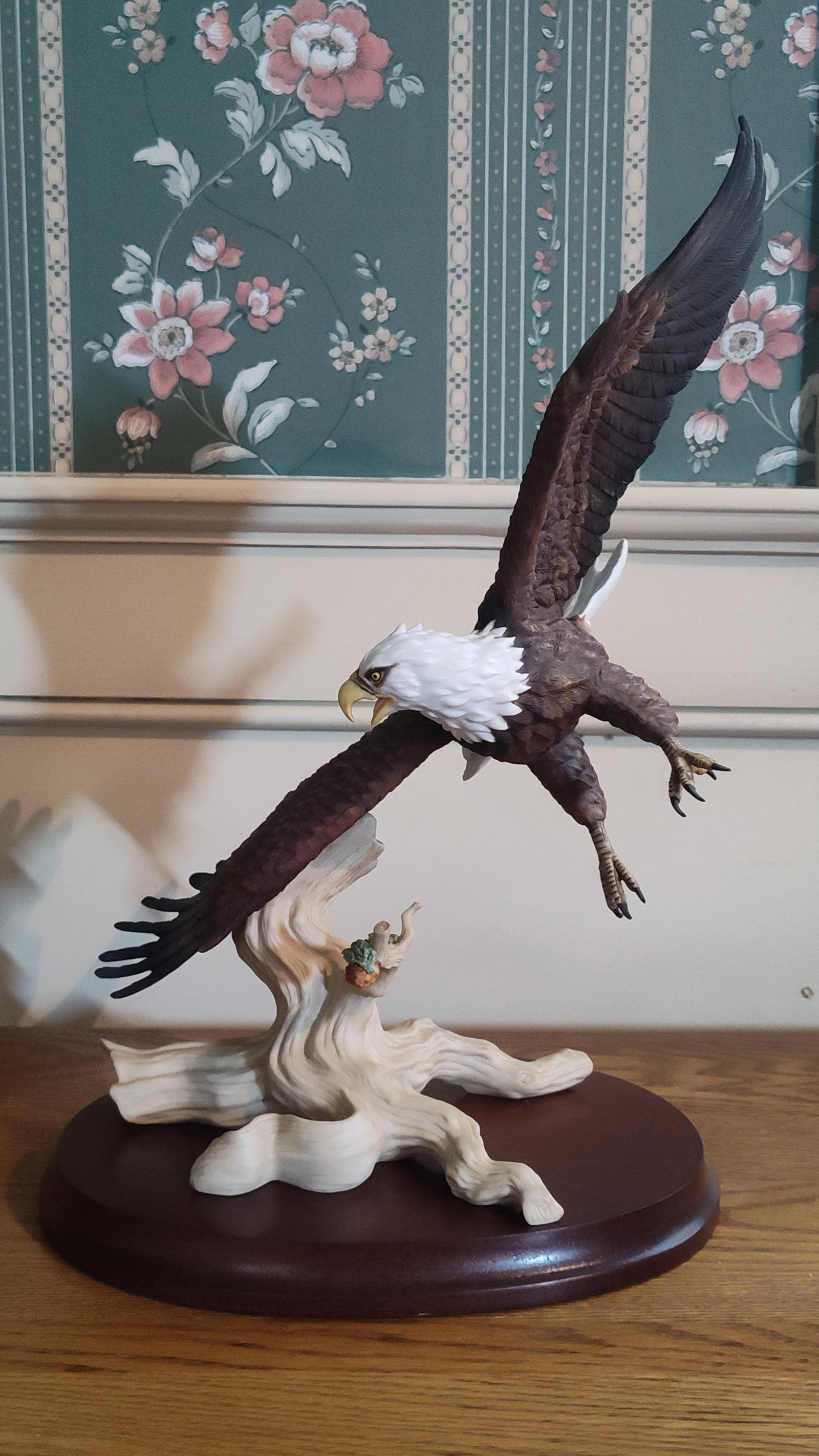 Lenox Smithsonian Porc. Bald Eagle Figurine 1989: This hand-painted bisque porcelain figurine, produced by Lenox in collaboration with the Smithsonian Institution, depicts a bald eagle in a dynamic flight pose. The eagle is captured descending toward