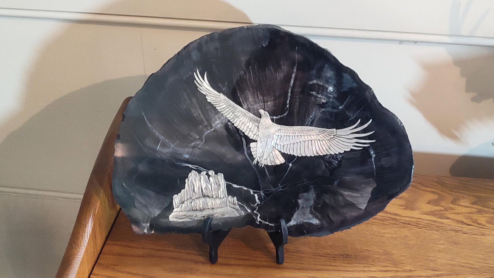 Atlee Raber Eagle & Monument Valley Sculpture: This contemporary mixed media sculpture is produced by artist Atlee Raber, known for combining natural stone elements with cast metal figures. The piece centers on a large, irregularly shaped slice