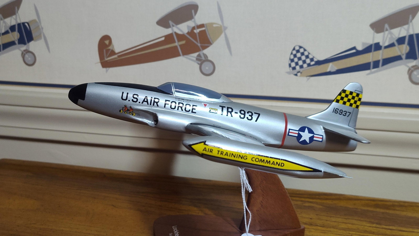 Lockheed T-33A Shooting Star Desktop Display Model: This is a professional desktop display model of a Lockheed T-33A Shooting Star jet trainer, attributed to Scalecraft. The item is constructed from solid wood with a silver painted finish and applied d