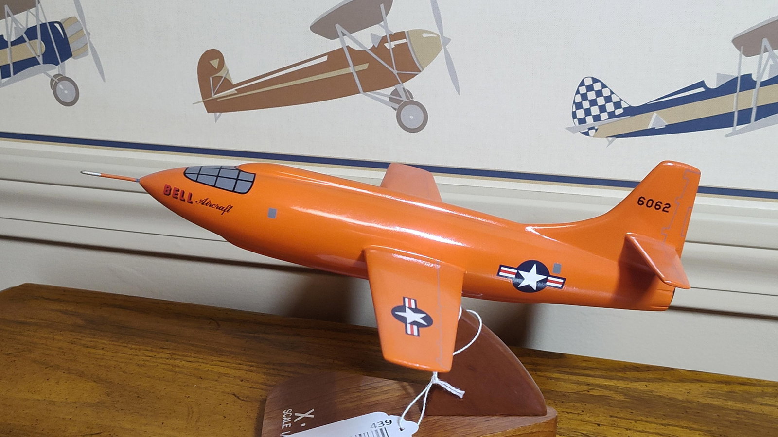 Bell X-1 Glamorous Glennis Desktop Display Model: This desktop display model represents the Bell X-1 supersonic research aircraft, specifically the Glamorous Glennis. The model is constructed from hand-carved wood with a high-gloss International