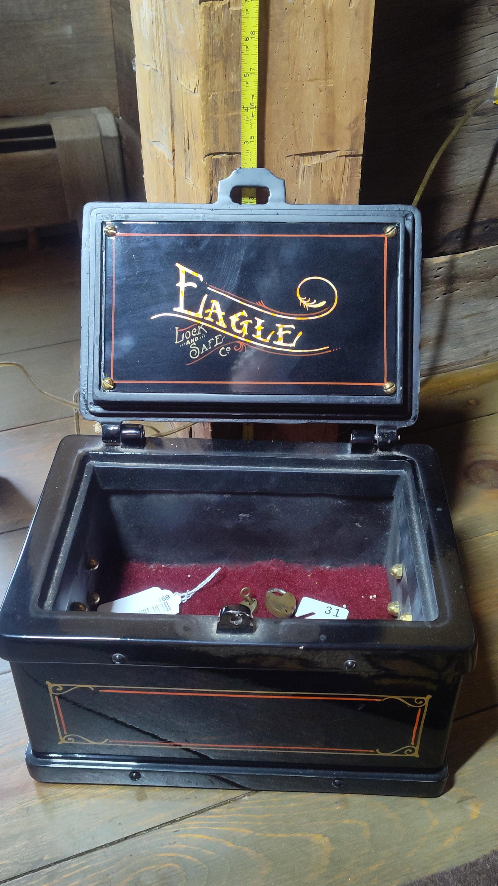 19th-century Wells Fargo express strongbox: This commemorative still bank is modeled after a 19th-century Wells Fargo express strongbox. The cast metal body features a high-gloss black finish decorated with orange and gold pinstriping. The