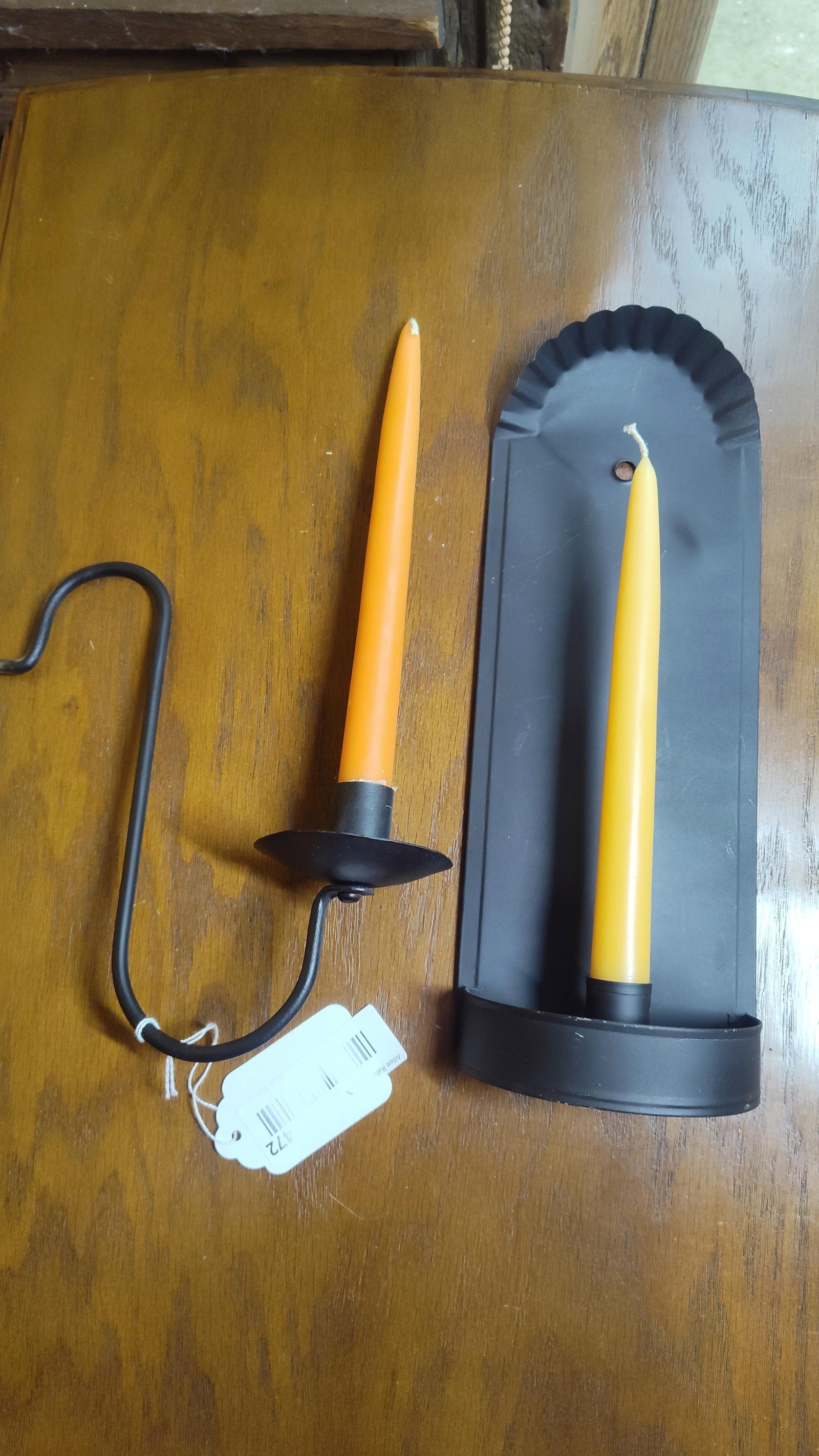 Pair Primitive Black Metal Candle Holders & Tapers: This lot features two black-painted metal candle holders crafted in a primitive Early American style. The first item is a wall-mounted sconce consisting of a rectangular backplate with a fluted